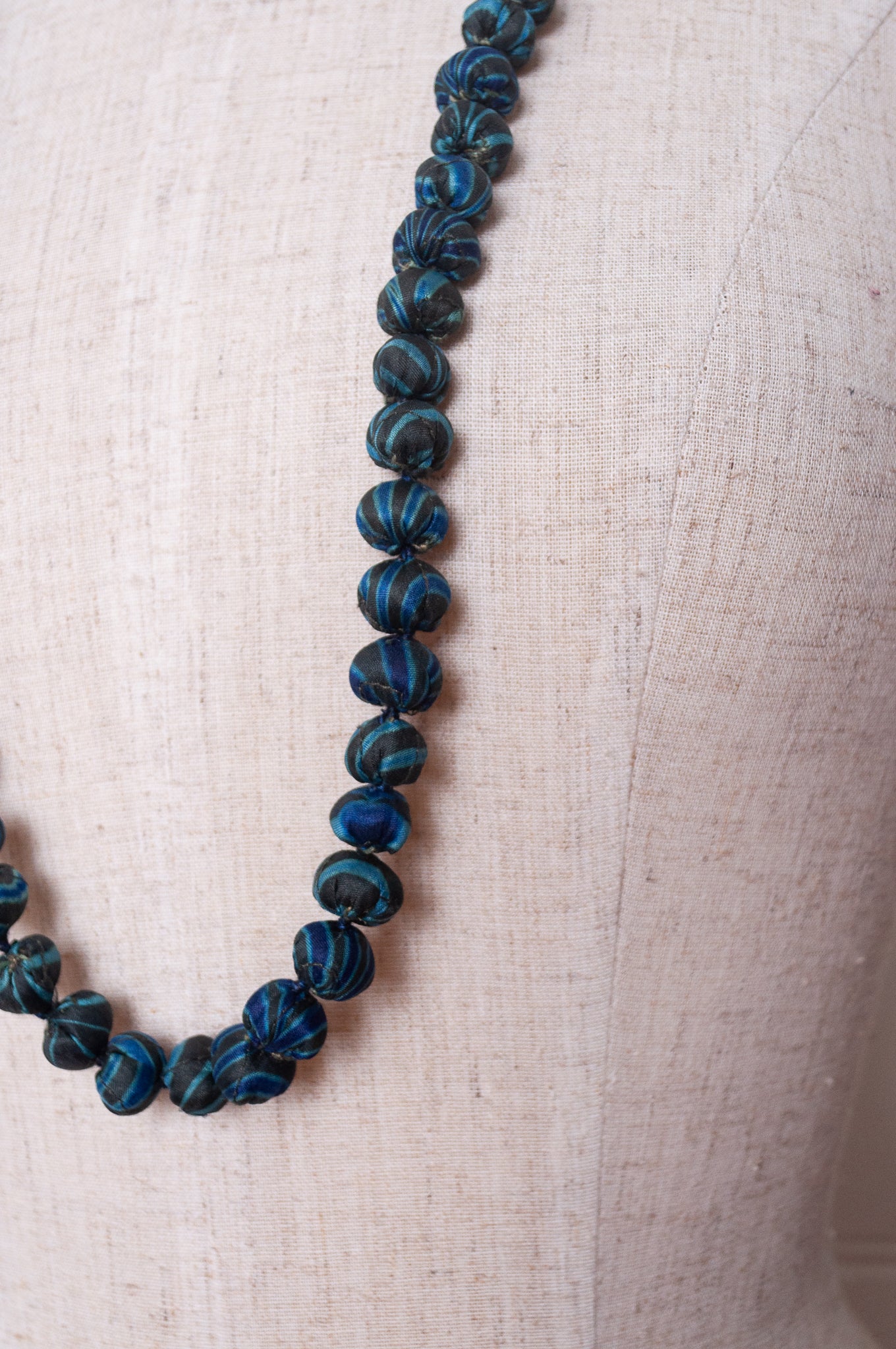 Neeru Kumar handmade fabric beads from silk shibori remnants in sapphire blue and green.