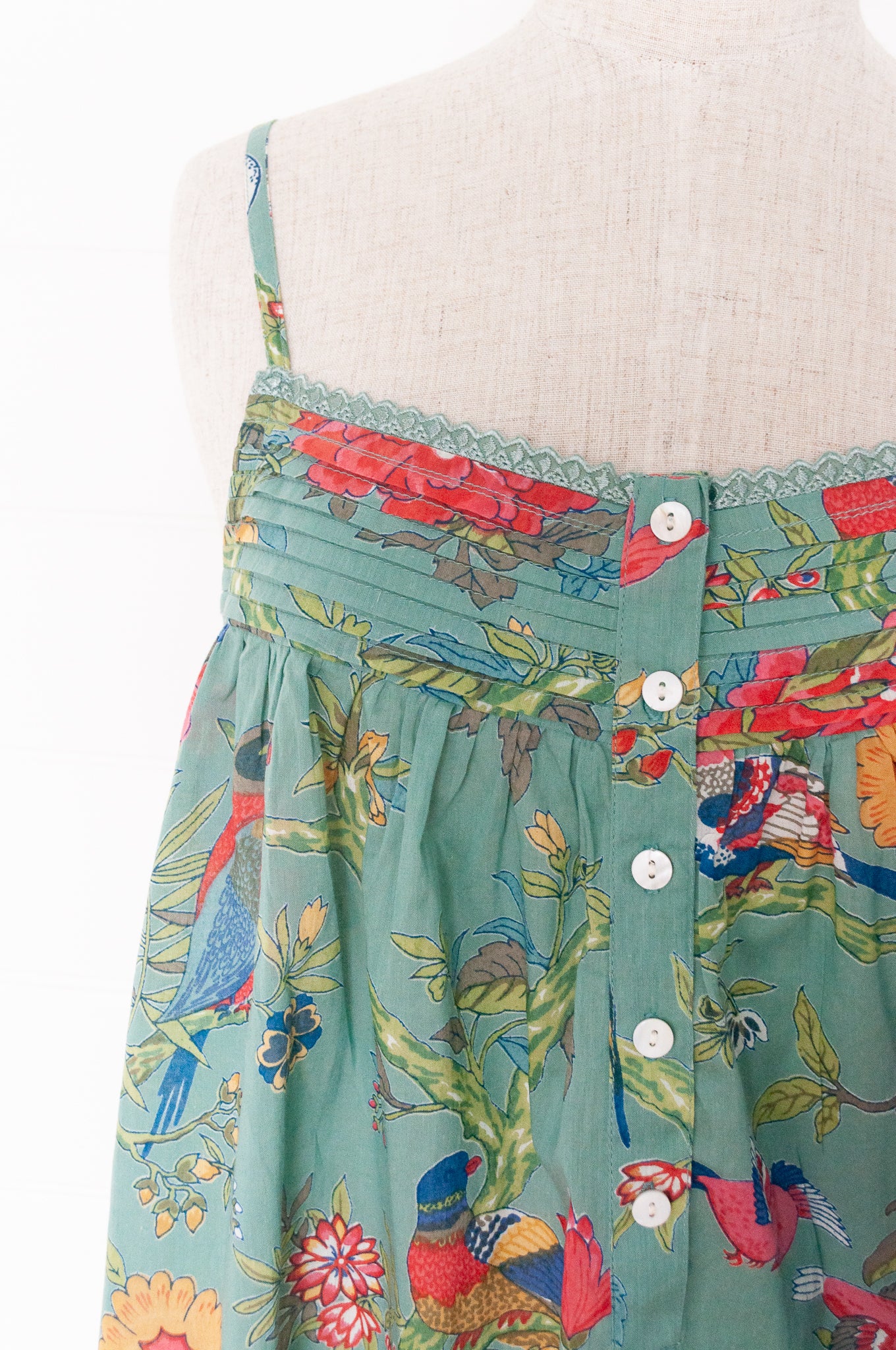 Juniper Hearth cotton voile nightdress with brightly coloured birds and flowers on an aqua background.