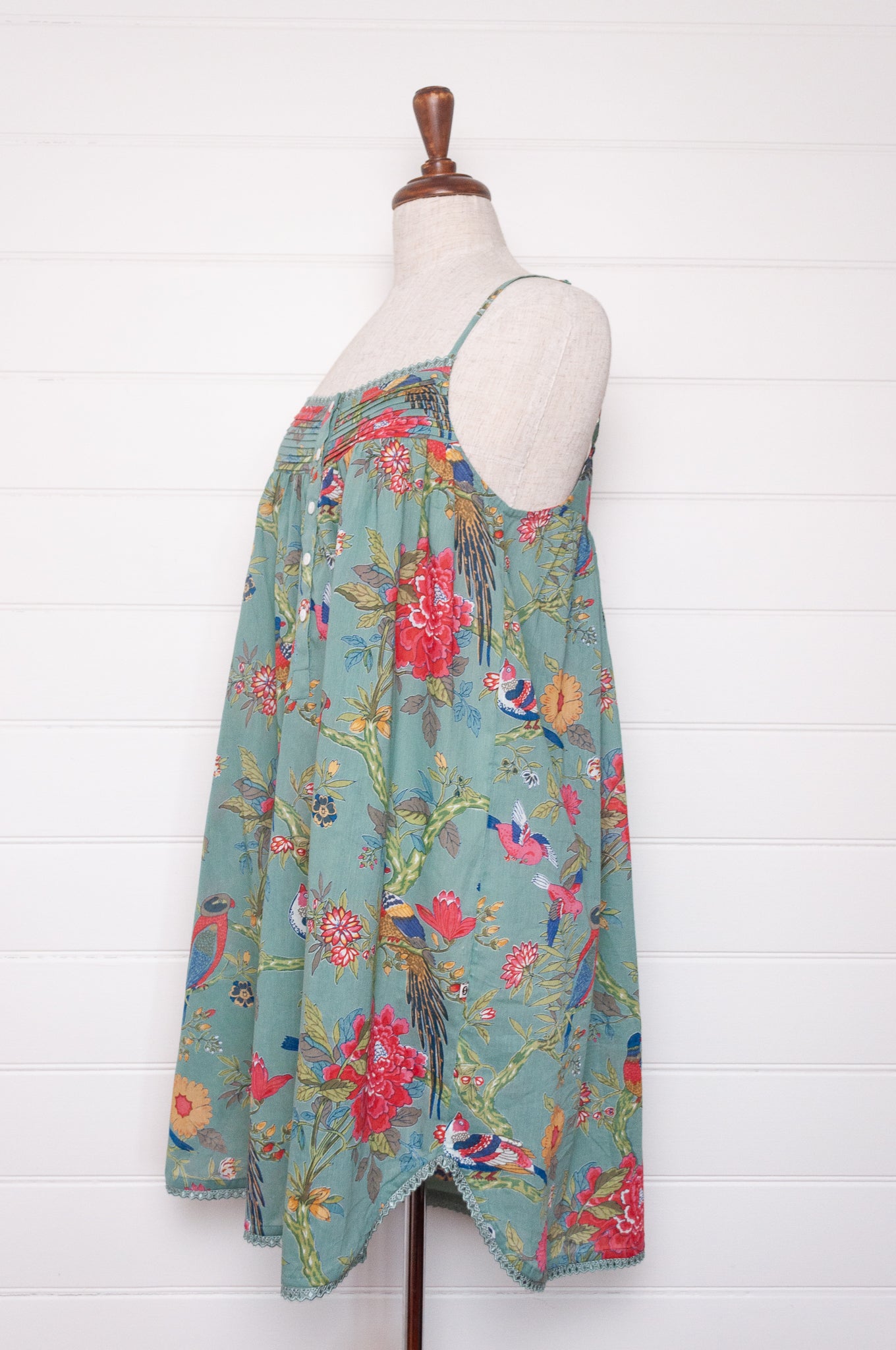 Juniper Hearth cotton voile nightdress with brightly coloured birds and flowers on an aqua background.