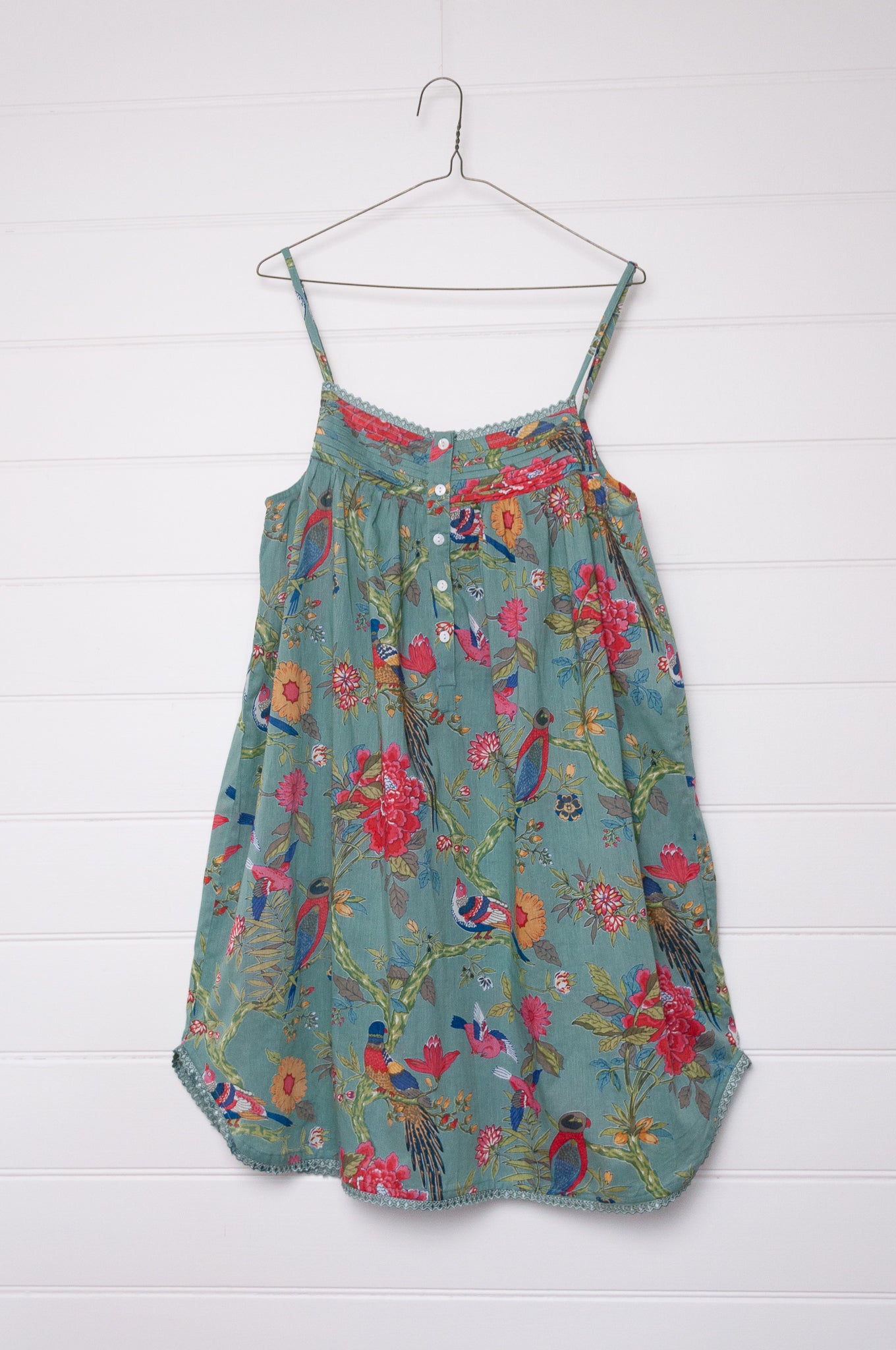 Juniper Hearth cotton voile nightdress with brightly coloured birds and flowers on an aqua background.
