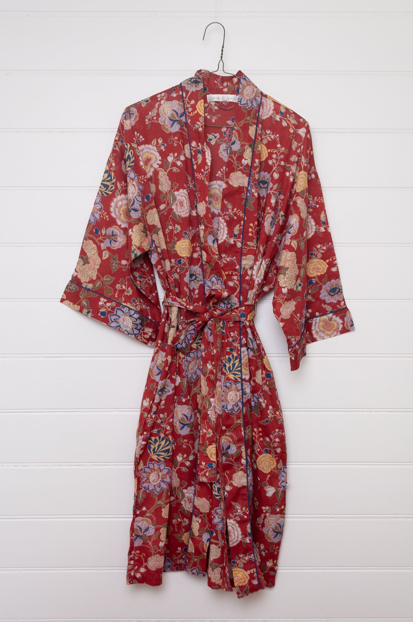 Juniper Hearth kimono in Malabar rust gold and cream and denim blue flowers on rust red background.