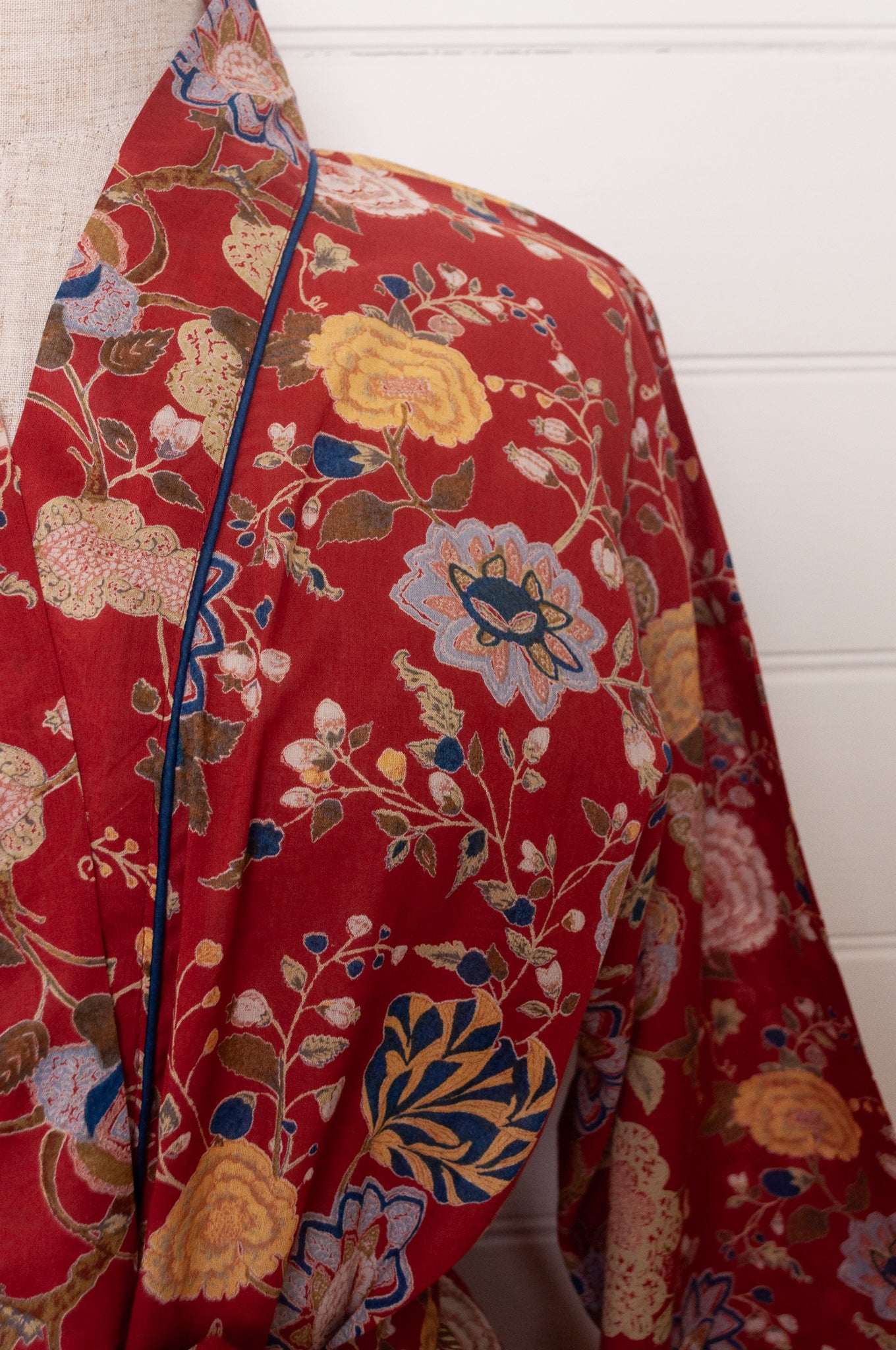 Juniper Hearth kimono in Malabar rust gold and cream and denim blue flowers on rust red background.