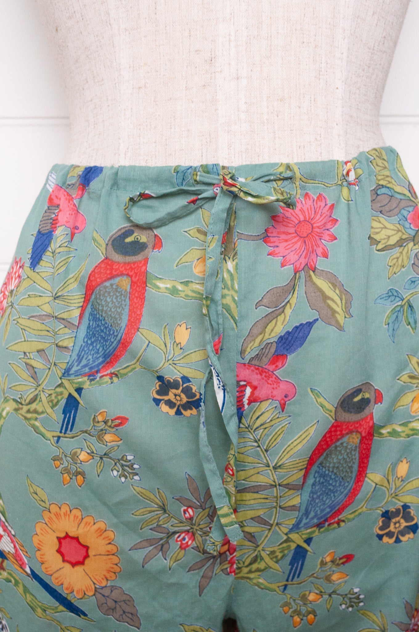 Juniper Hearth cotton voile pyjamas, screen printed with vibrant floral print on aqua blue background.