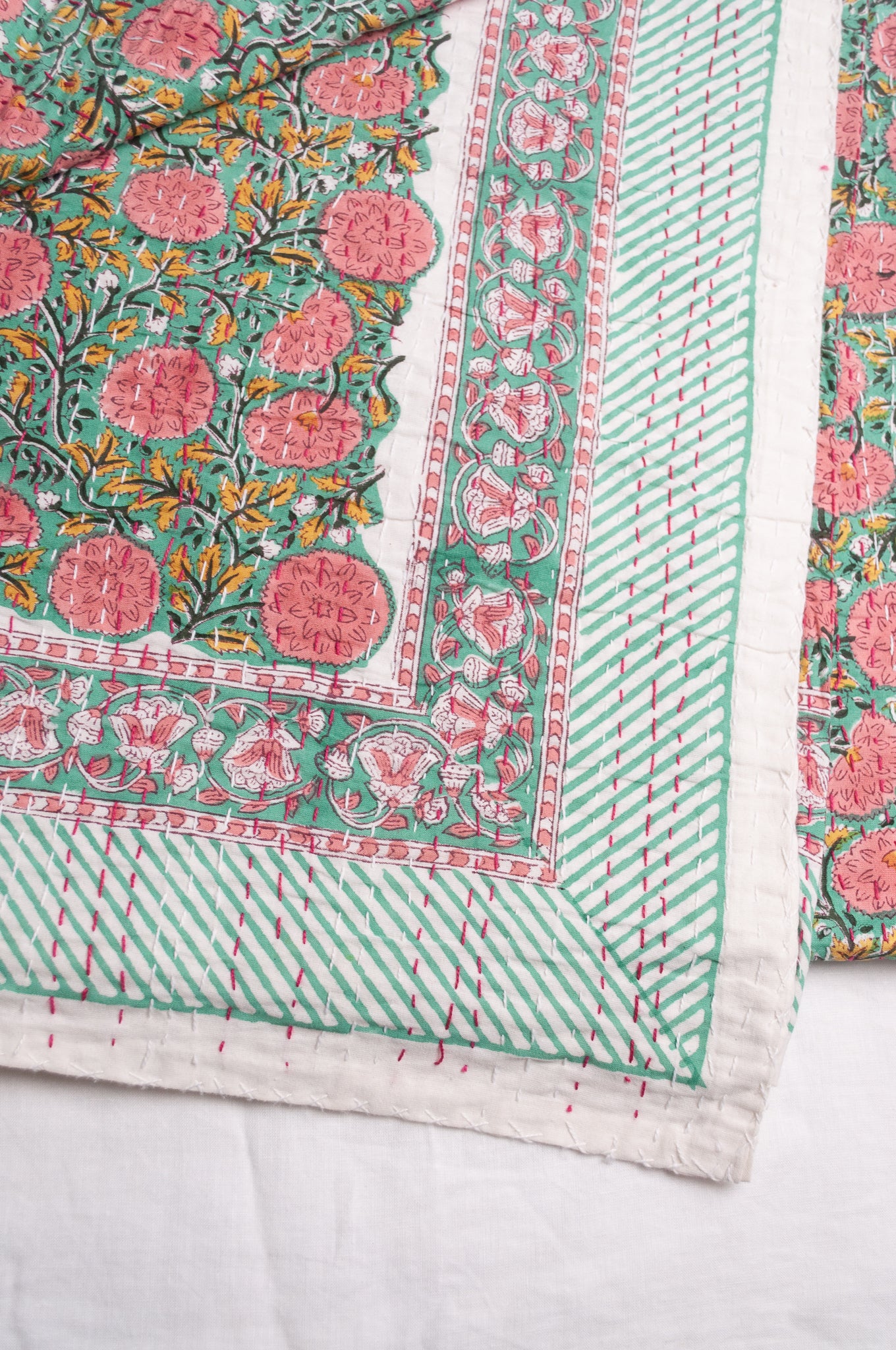 Hand stitched block print pure cotton kantha quilt pink and yellow floral on mint green.