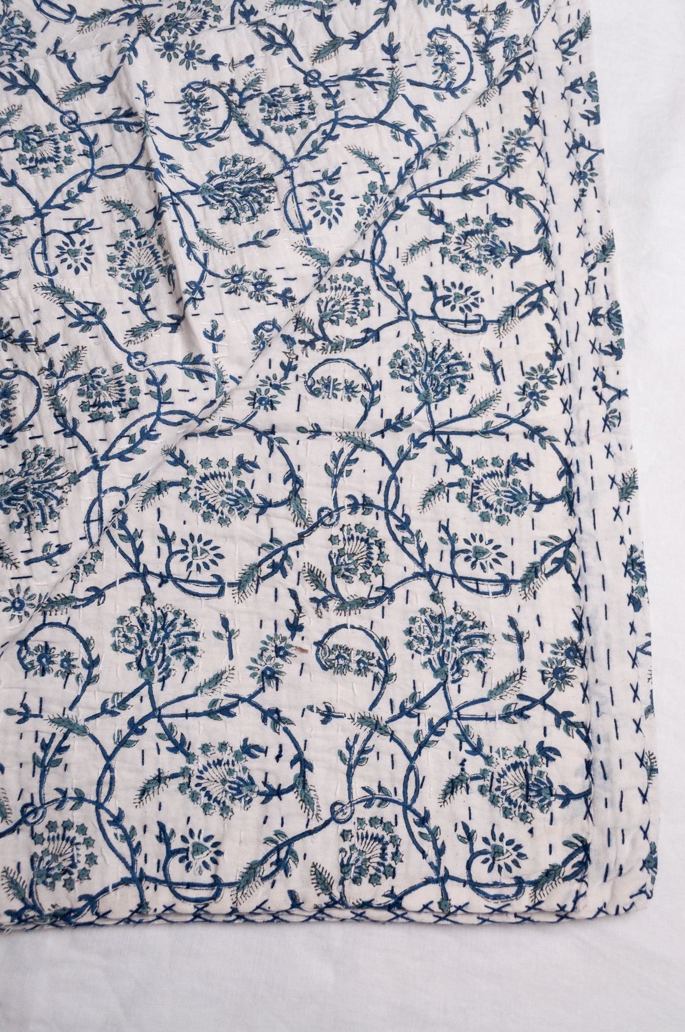 Hand stitched block print pure cotton kantha quilt indigo blue floral and vine on white.