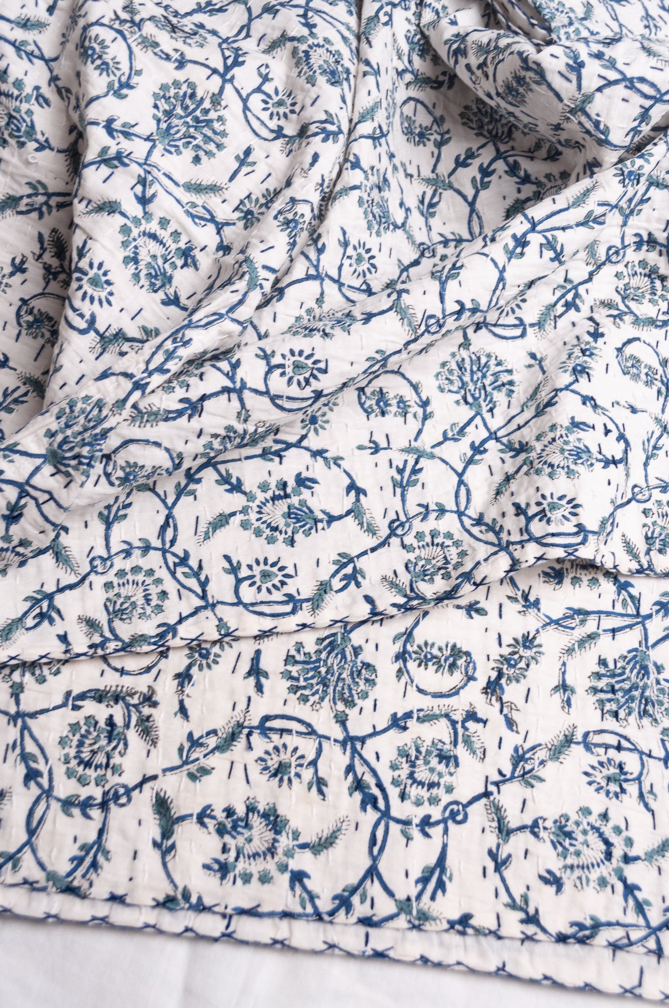 Hand stitched block print pure cotton kantha quilt indigo blue floral and vine on white.