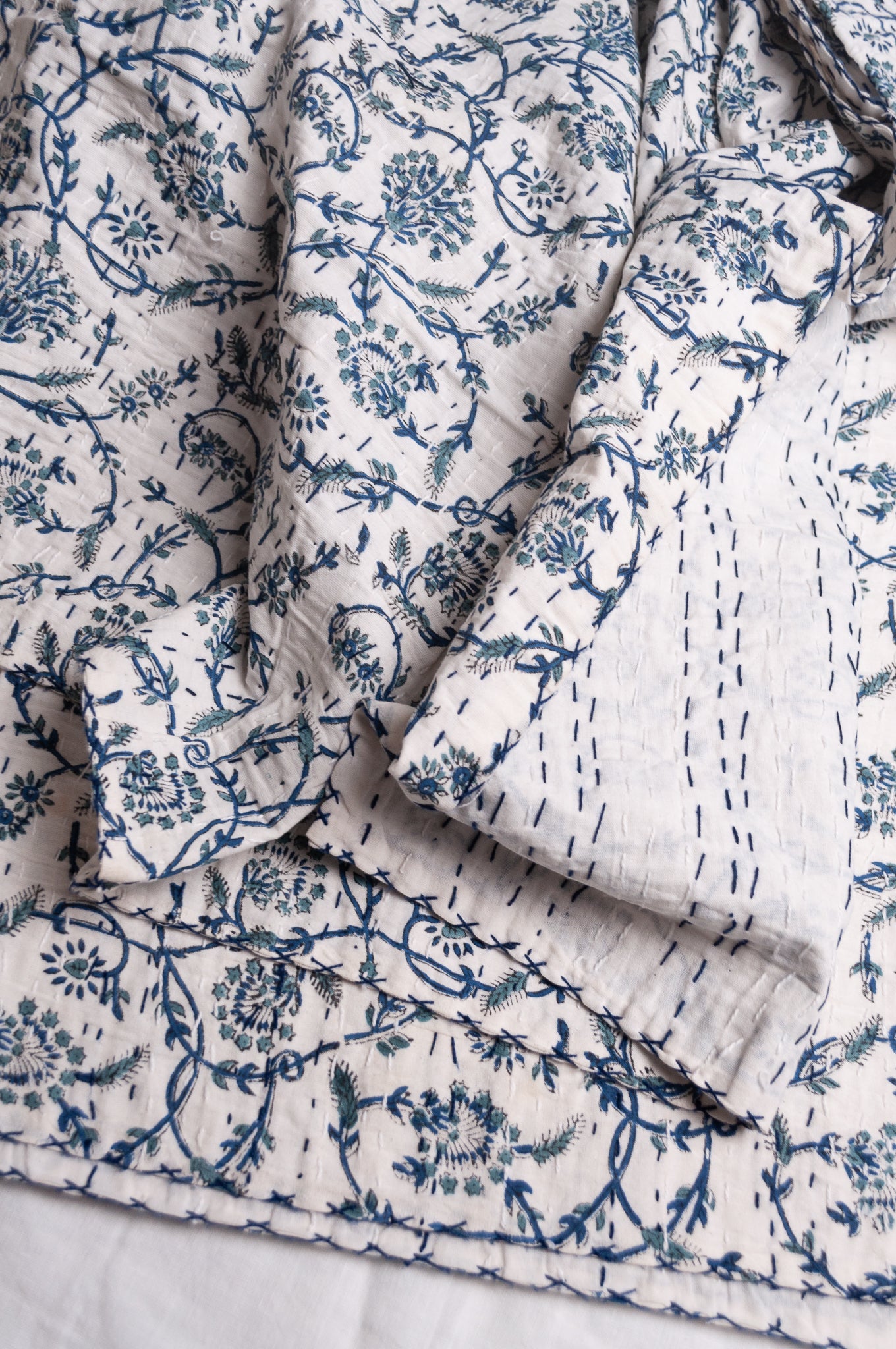 Hand stitched block print pure cotton kantha quilt indigo blue floral and vine on white.