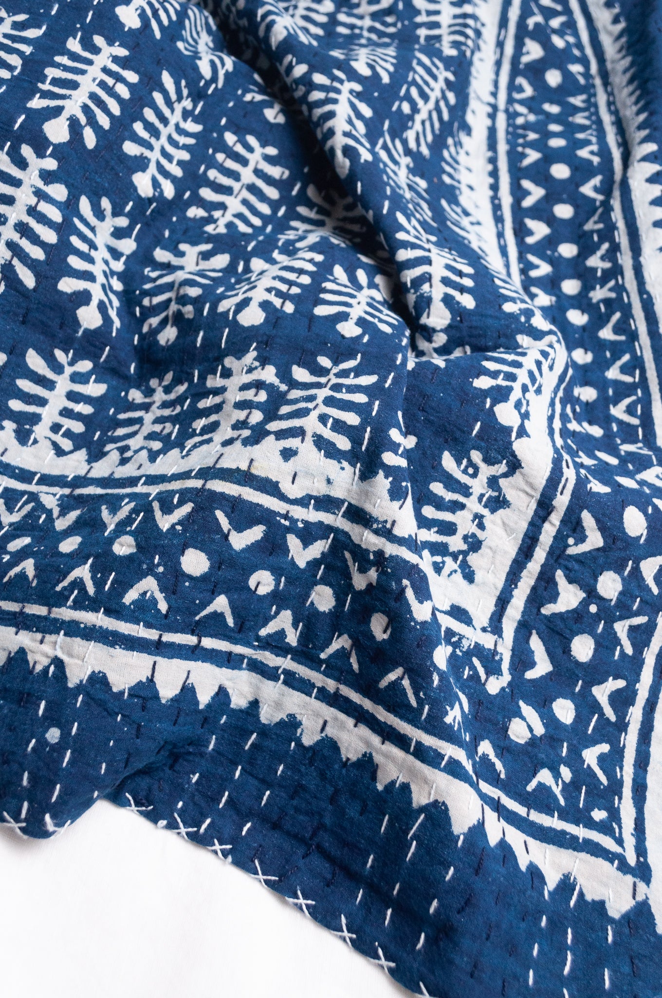 Indigo and white blockprint bhuti design handstitched cotton kantha quilt.