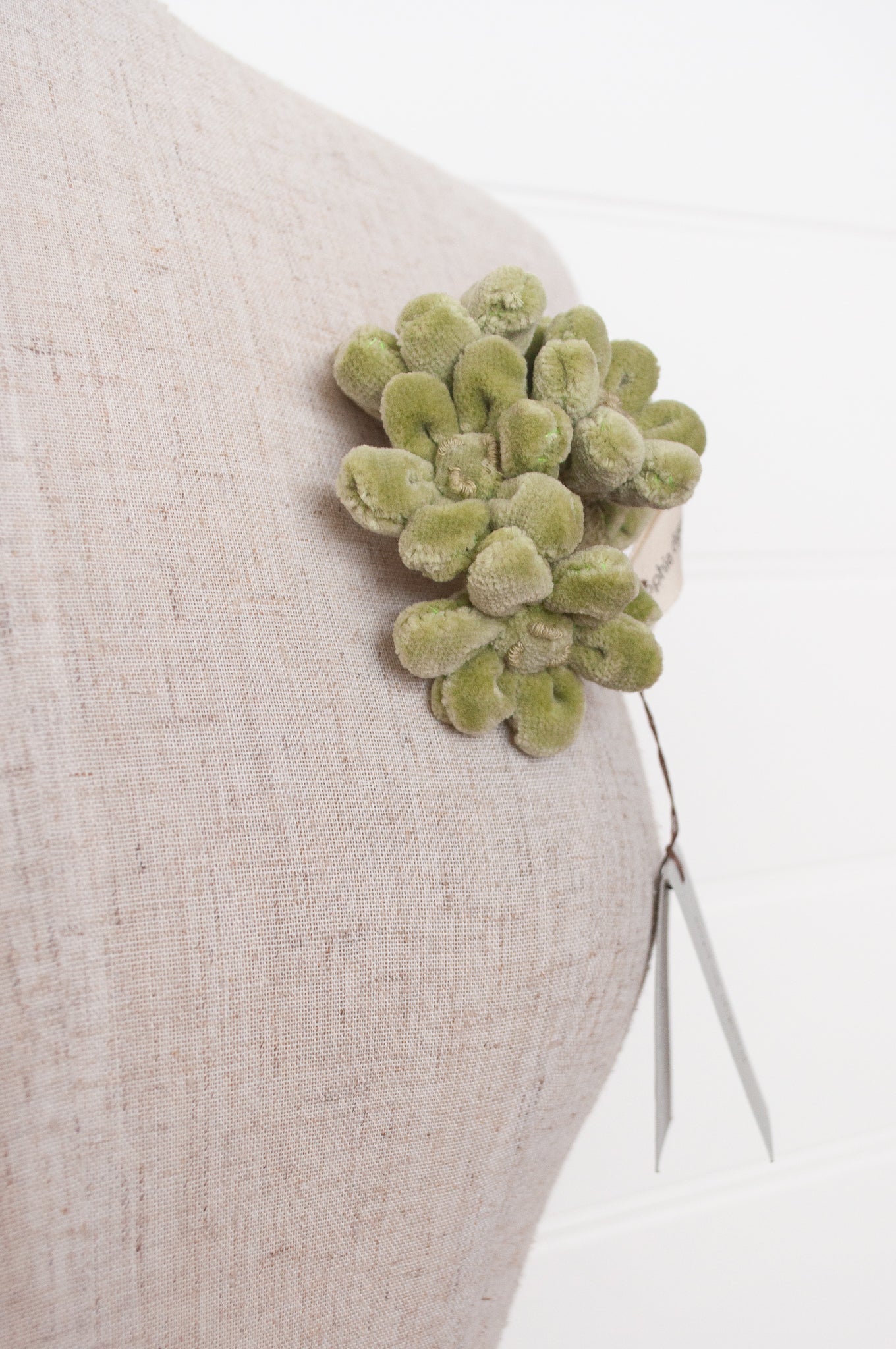 Sophie Digard velour flower jonquille brooch in soft sage green.