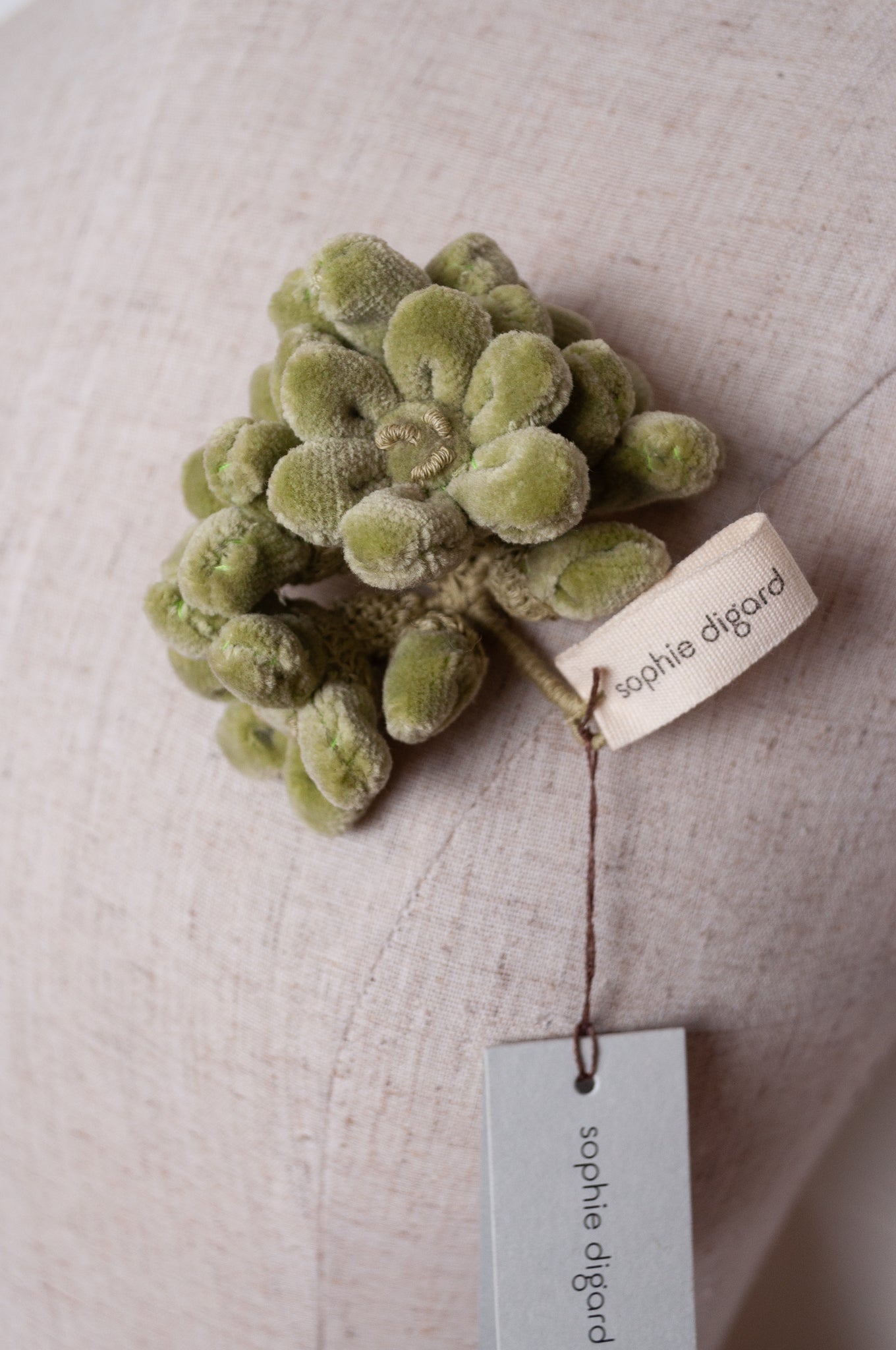 Sophie Digard velour flower jonquille brooch in soft sage green.