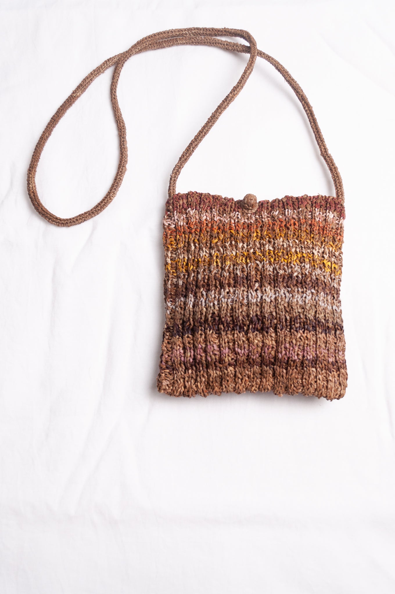 Sophie Digard small knitted raffia cross body bag in stripes of natural earthy tones.