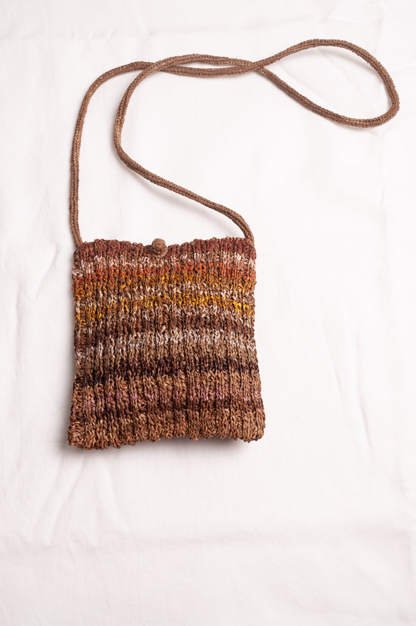Sophie Digard small knitted raffia cross body bag in stripes of natural earthy tones.