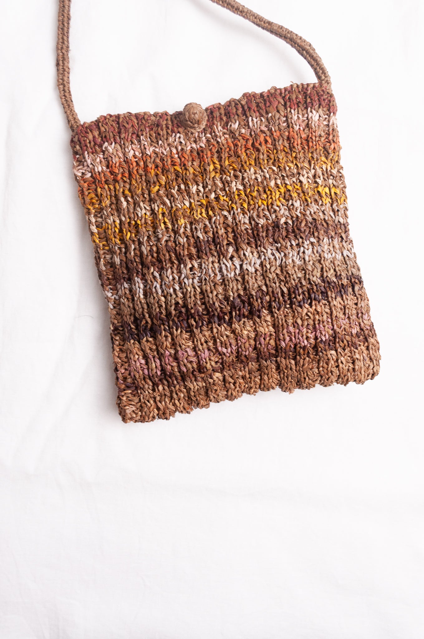 Sophie Digard small knitted raffia cross body bag in stripes of natural earthy tones.