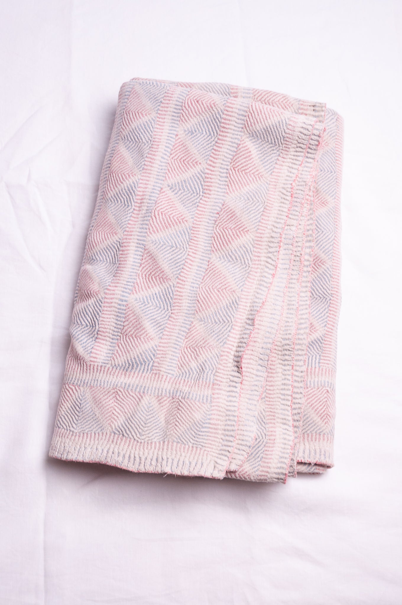 Vintage pink and blue on white lohori kantha quilt.