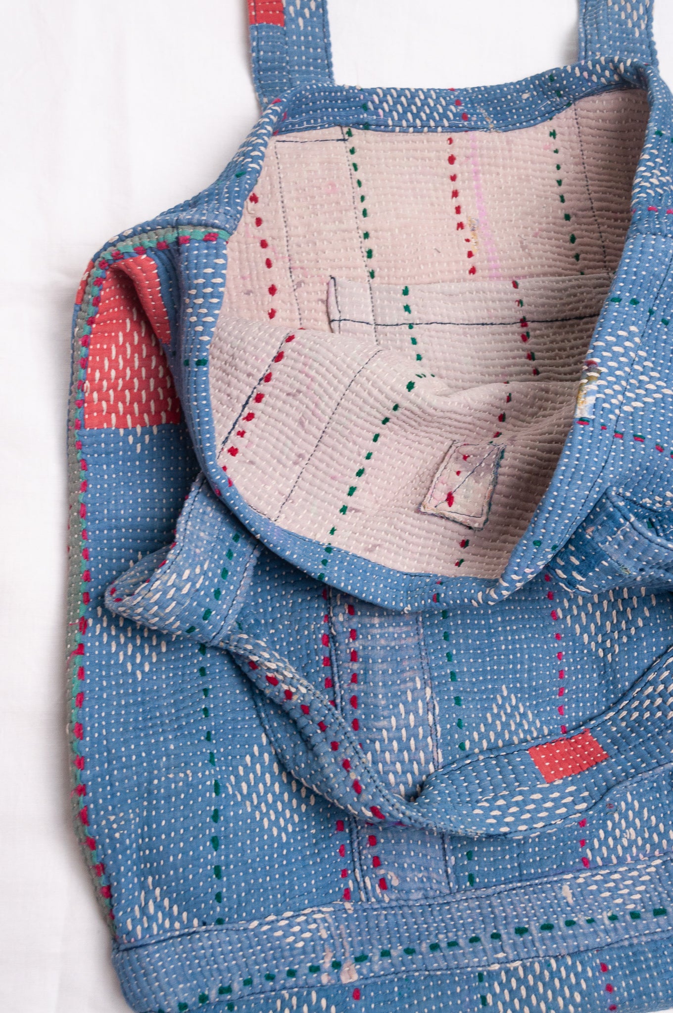 Vintage kantha quilt tote bag in sky blue with white embroidery.