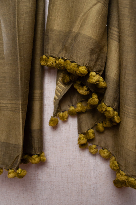 Silk and cotton scarf with pom poms in olive green.