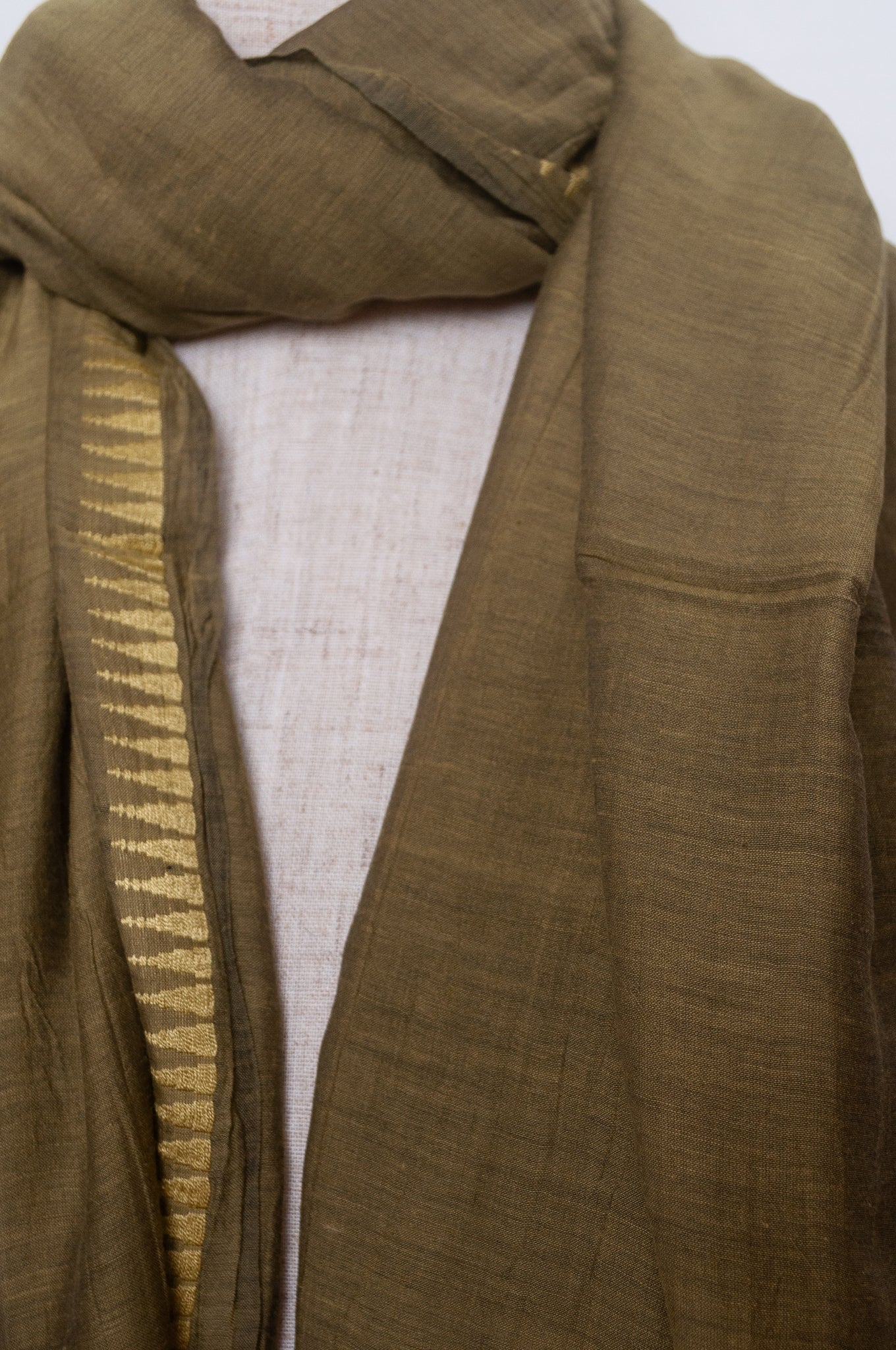 Silk and cotton scarf with pom poms in olive green.