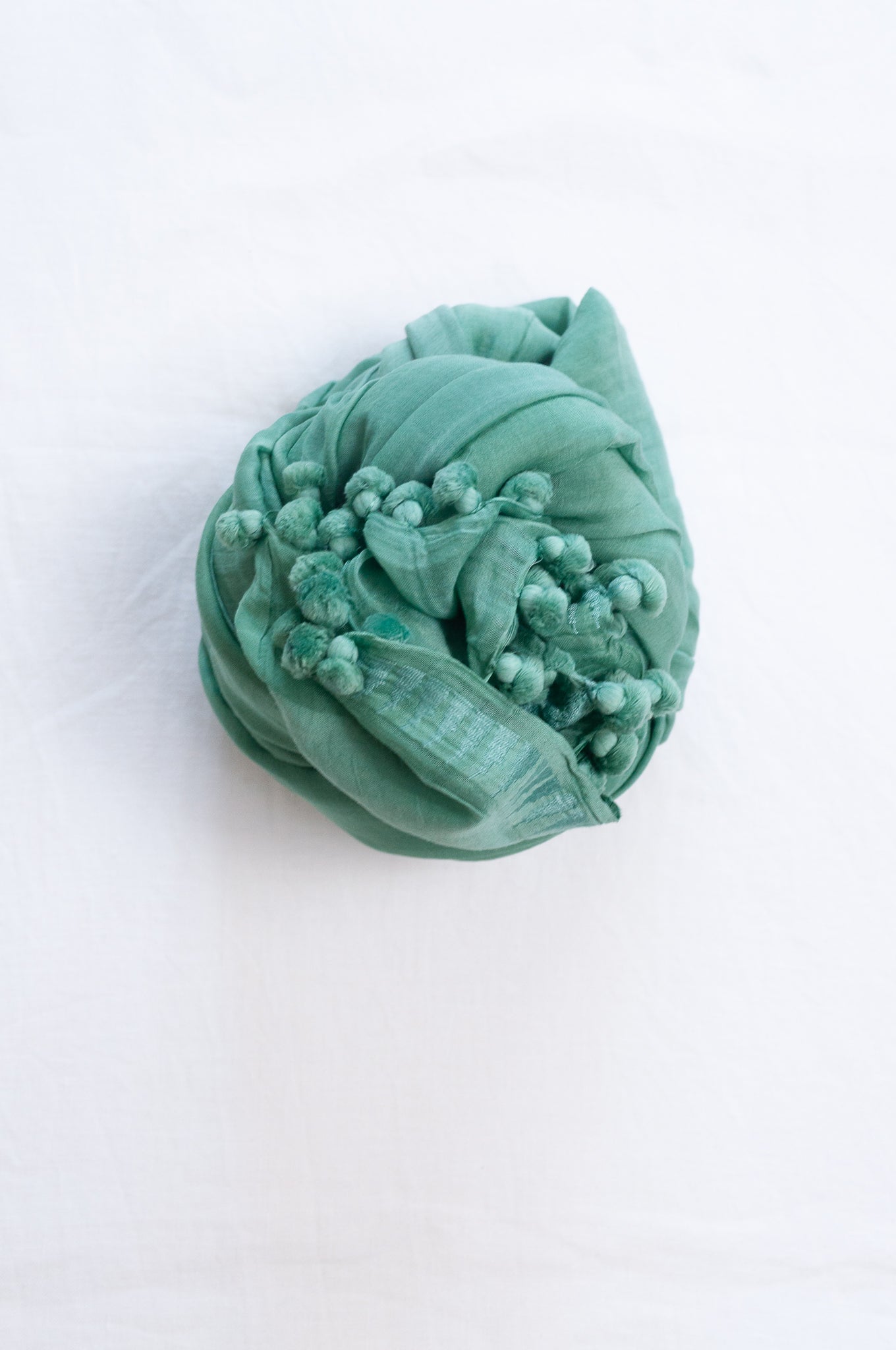 Silk and cotton scarf with pom poms in aqua green.