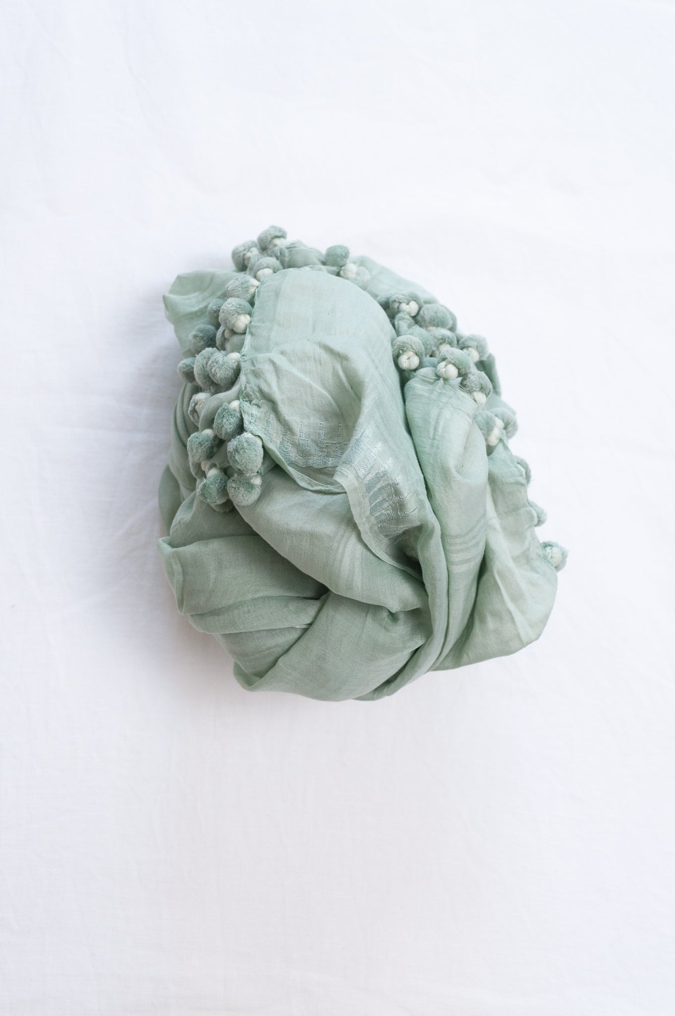 Silk and cotton scarf with pom poms in light aqua celadon green.