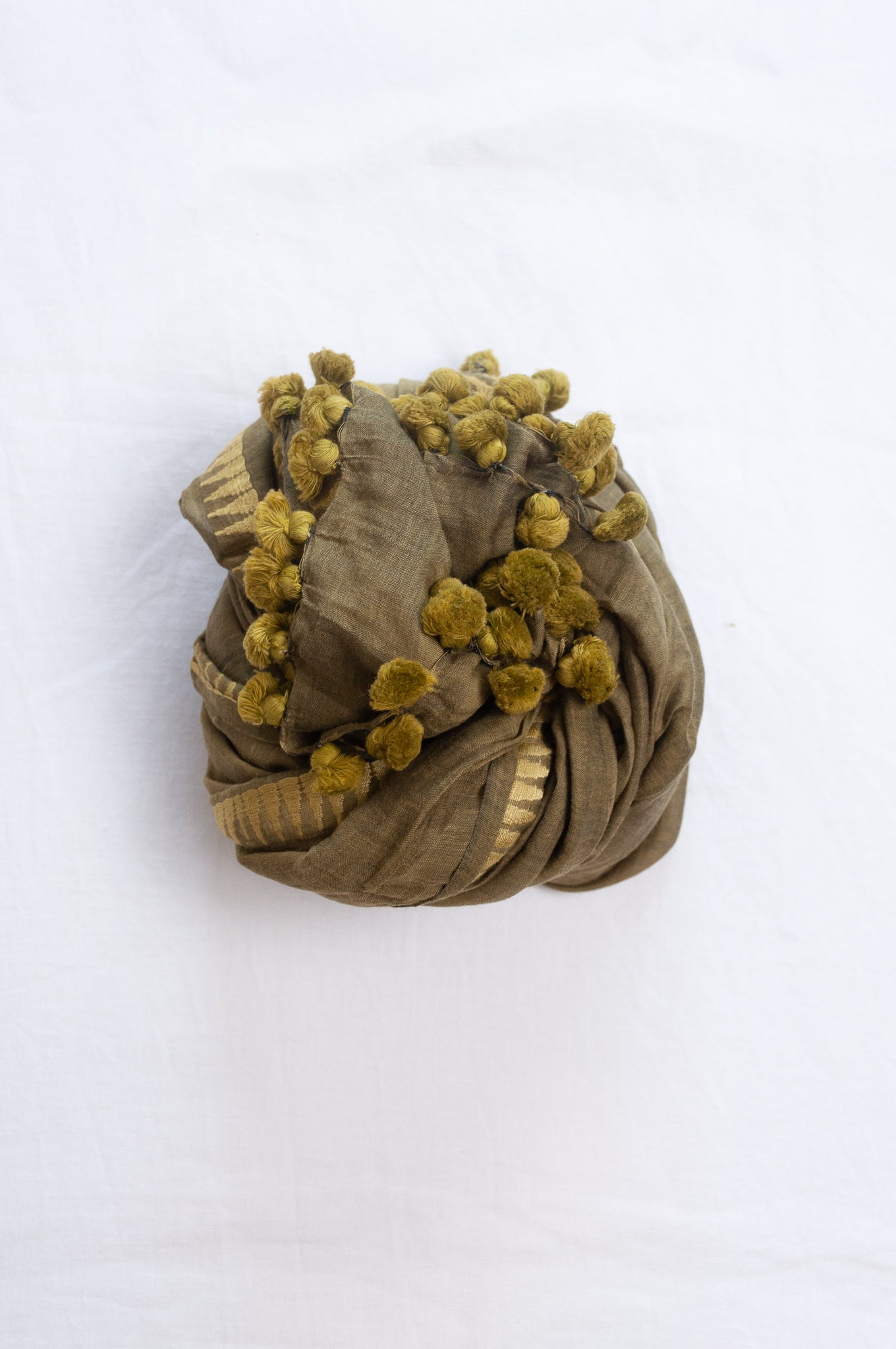 Silk and cotton scarf with pom poms in olive green.