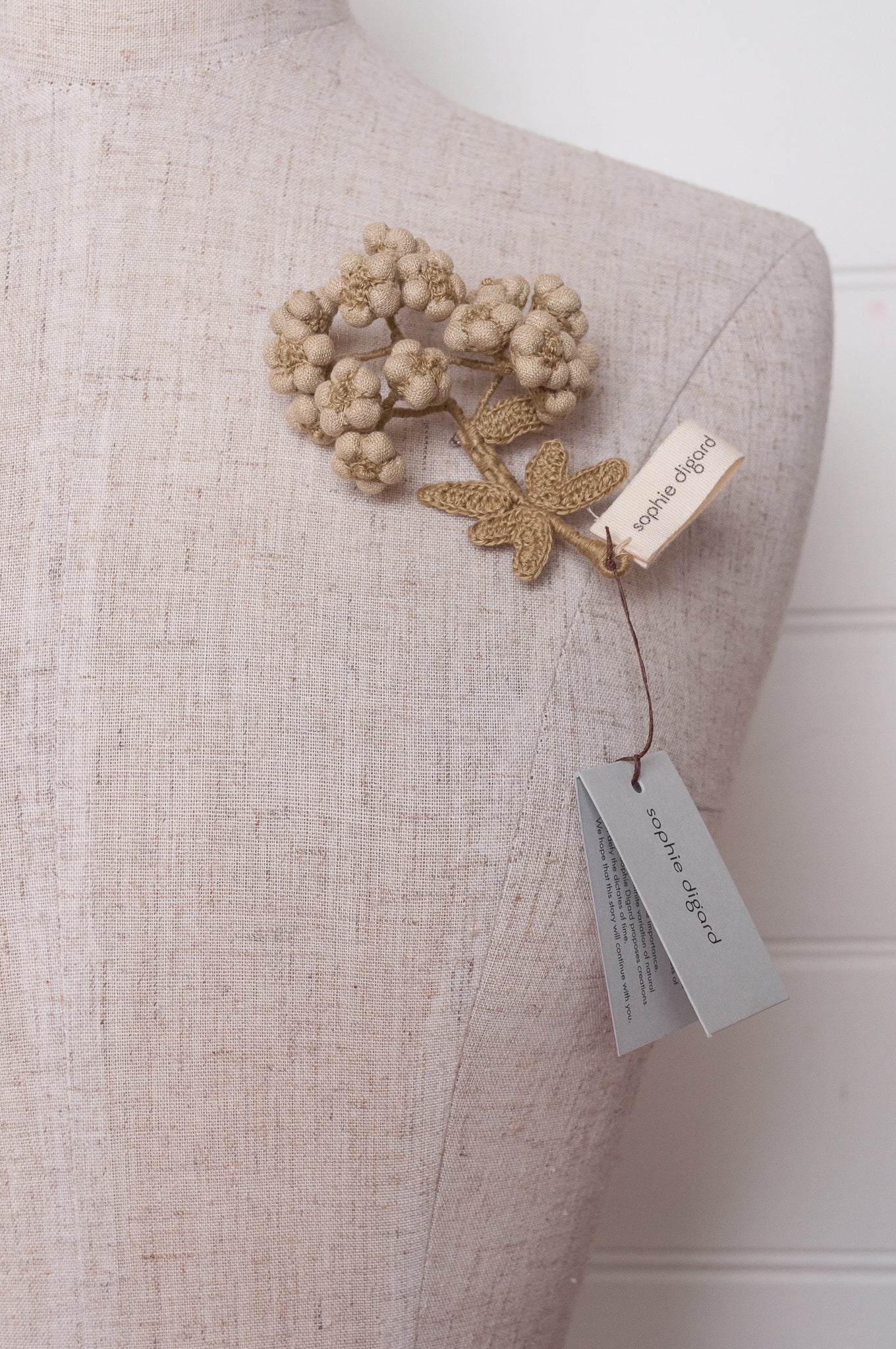 Handcrafted brooch by Sophie Digard, featuring embroidered flowers in thyme green linen.