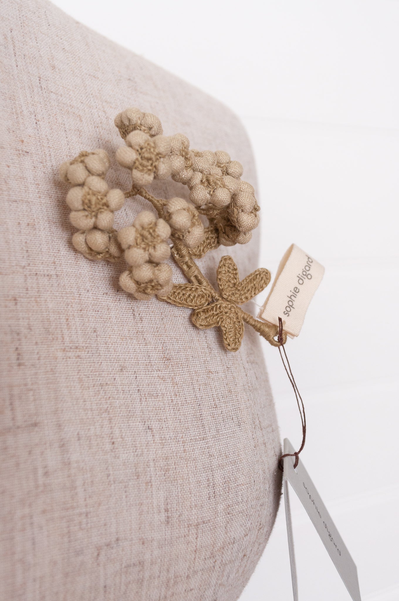 Handcrafted brooch by Sophie Digard, featuring embroidered flowers in thyme green linen.