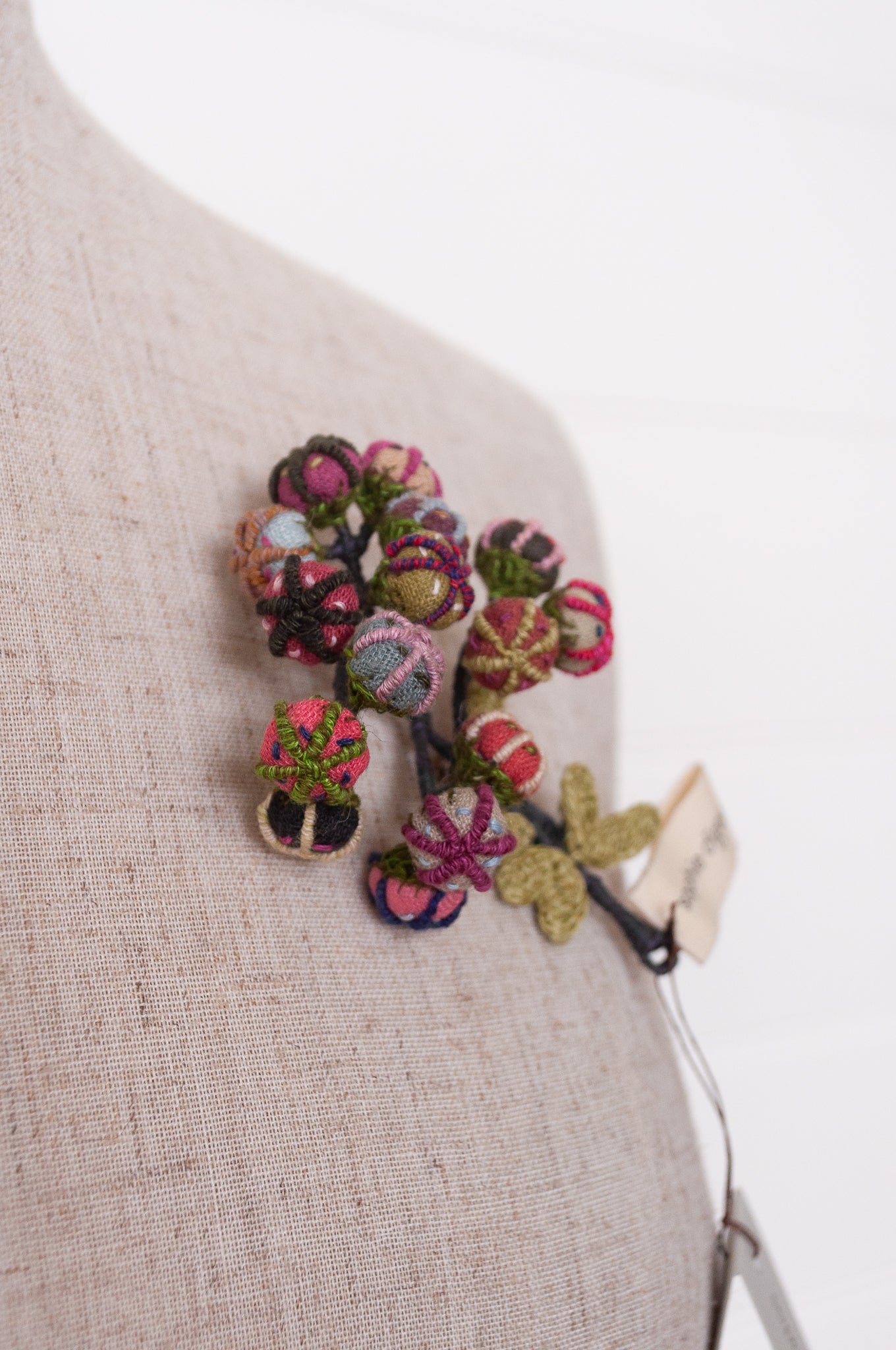 Handcrafted brooch by Sophie Digard, featuring small embroidered button flowers in linen.