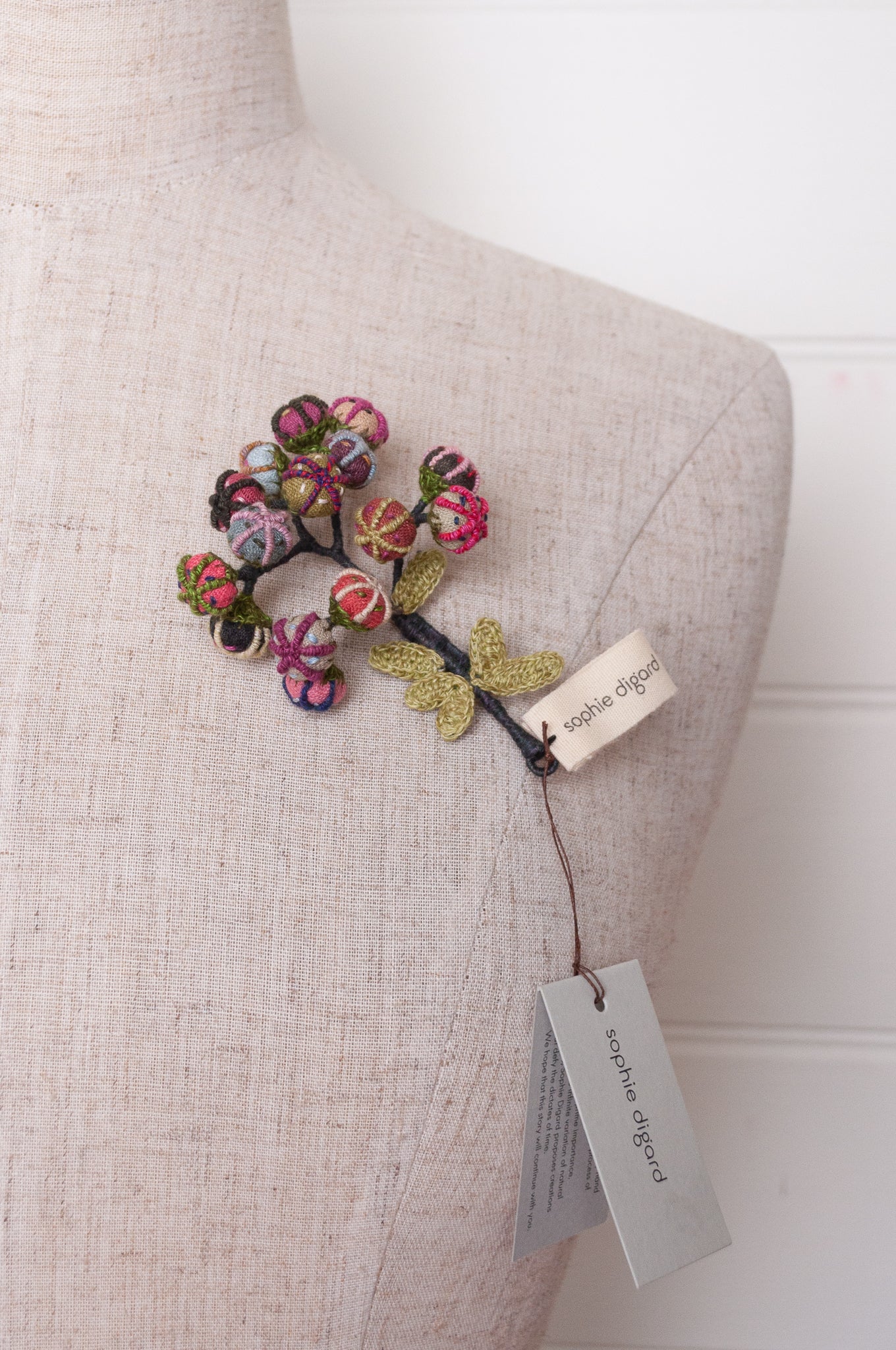 Handcrafted brooch by Sophie Digard, featuring small embroidered button flowers in linen.