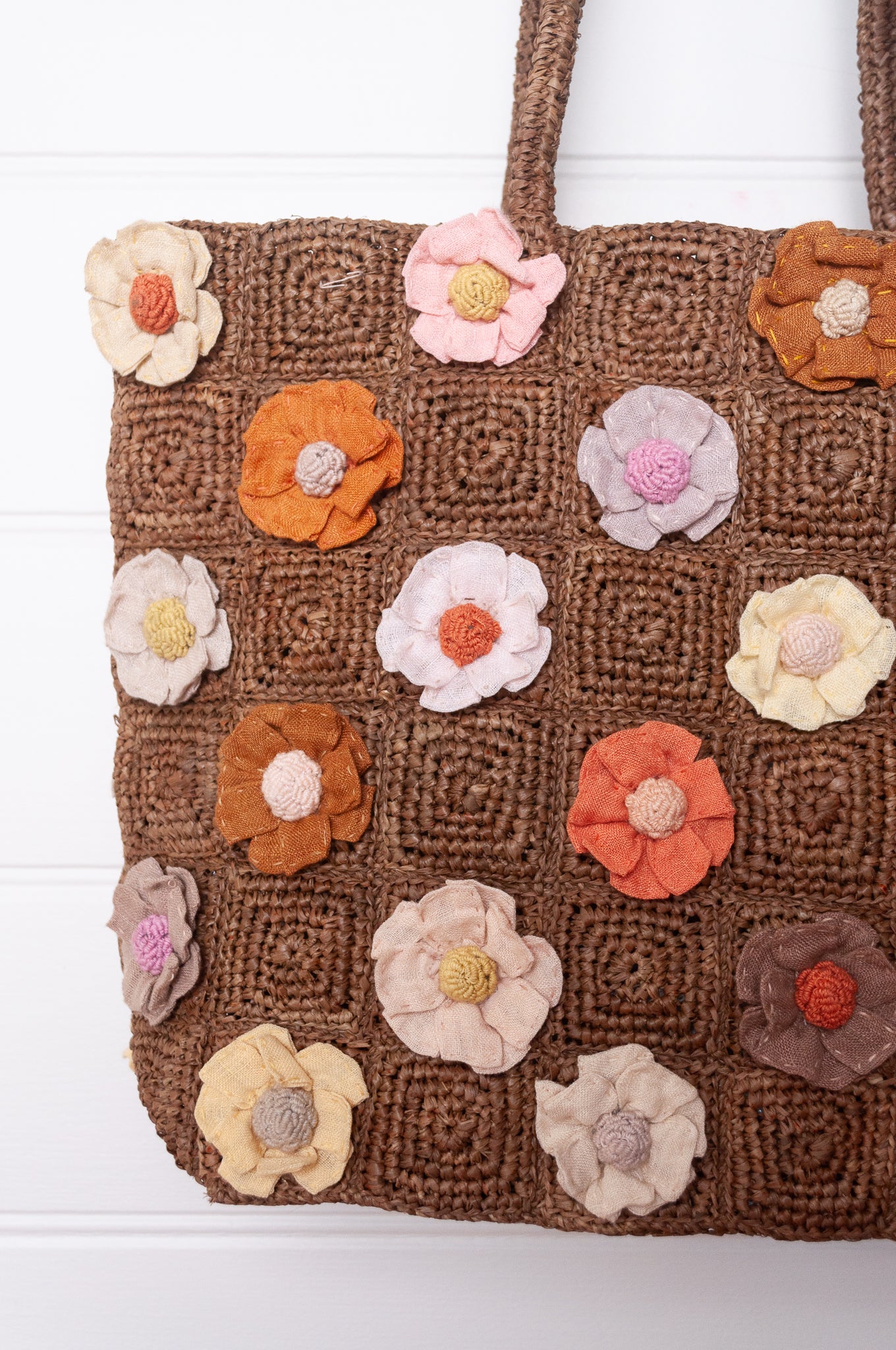 Sophie Digard crocheted raffia bag in tan with appliqued and embroidered linen flowers in warm neutrals.