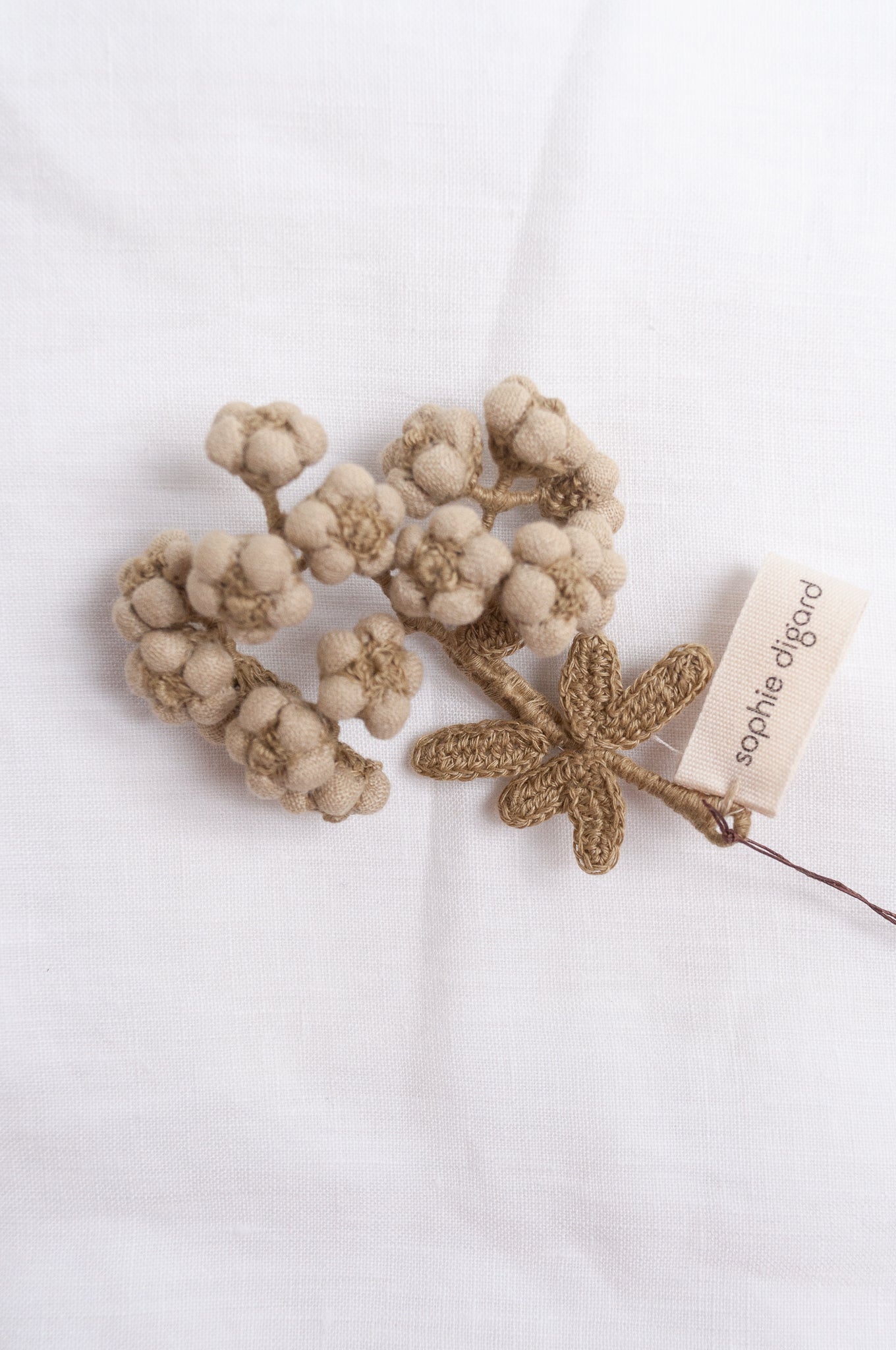 Handcrafted brooch by Sophie Digard, featuring embroidered flowers in thyme green linen.
