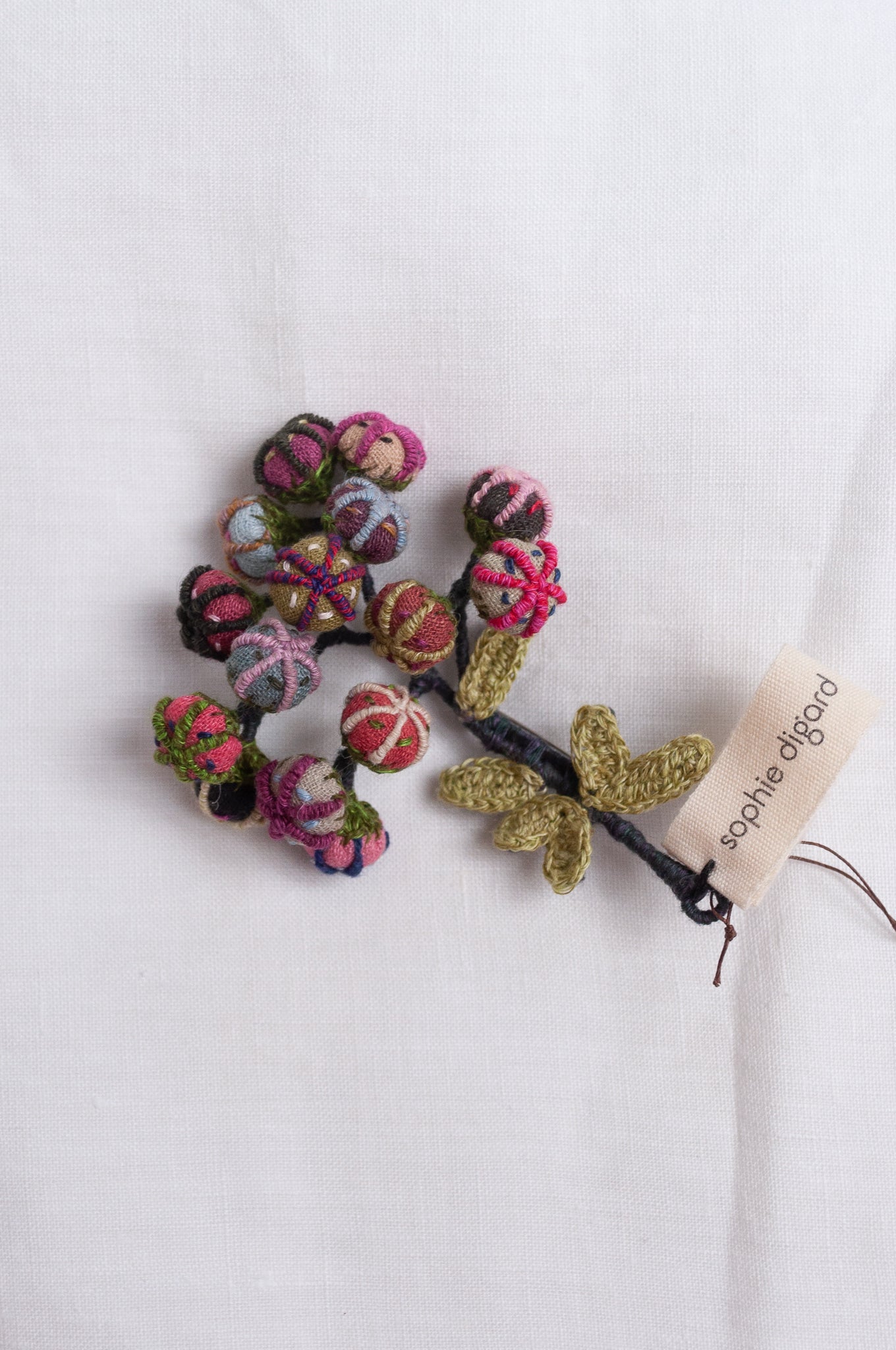 Handcrafted brooch by Sophie Digard, featuring small embroidered button flowers in linen.