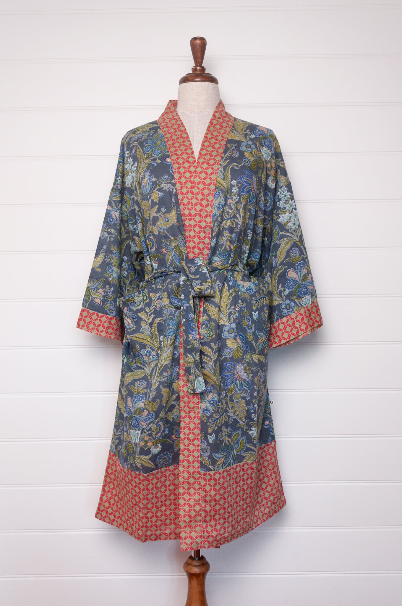 Juniper Hearth cotton voile kimono in tropical storm print, blue and olive green flowers on grey blue background.