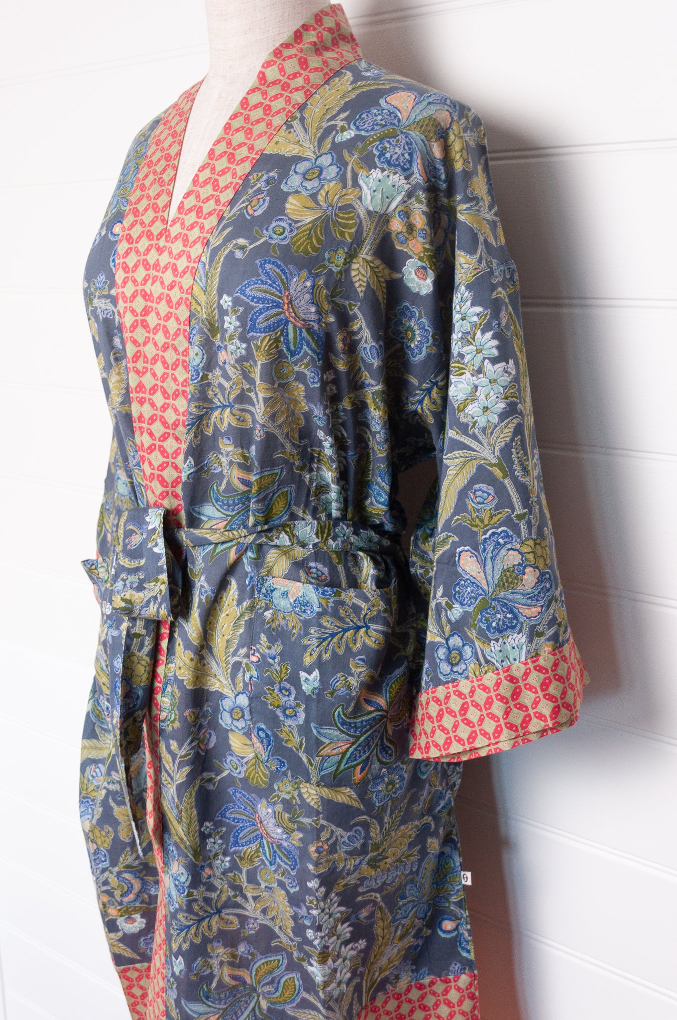 Juniper Hearth cotton voile kimono in tropical storm print, blue and olive green flowers on grey blue background.