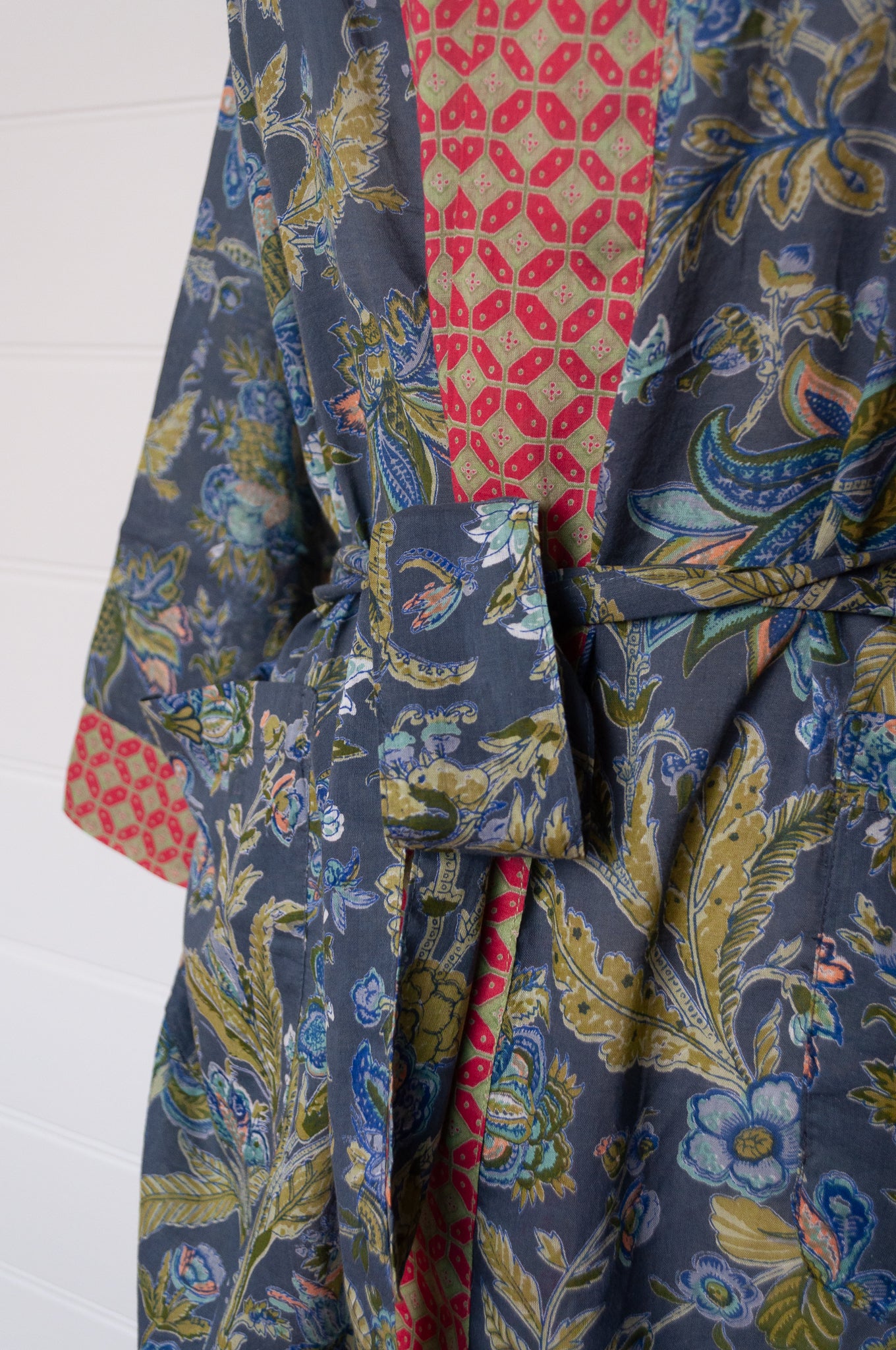 Juniper Hearth cotton voile kimono in tropical storm print, blue and olive green flowers on grey blue background.