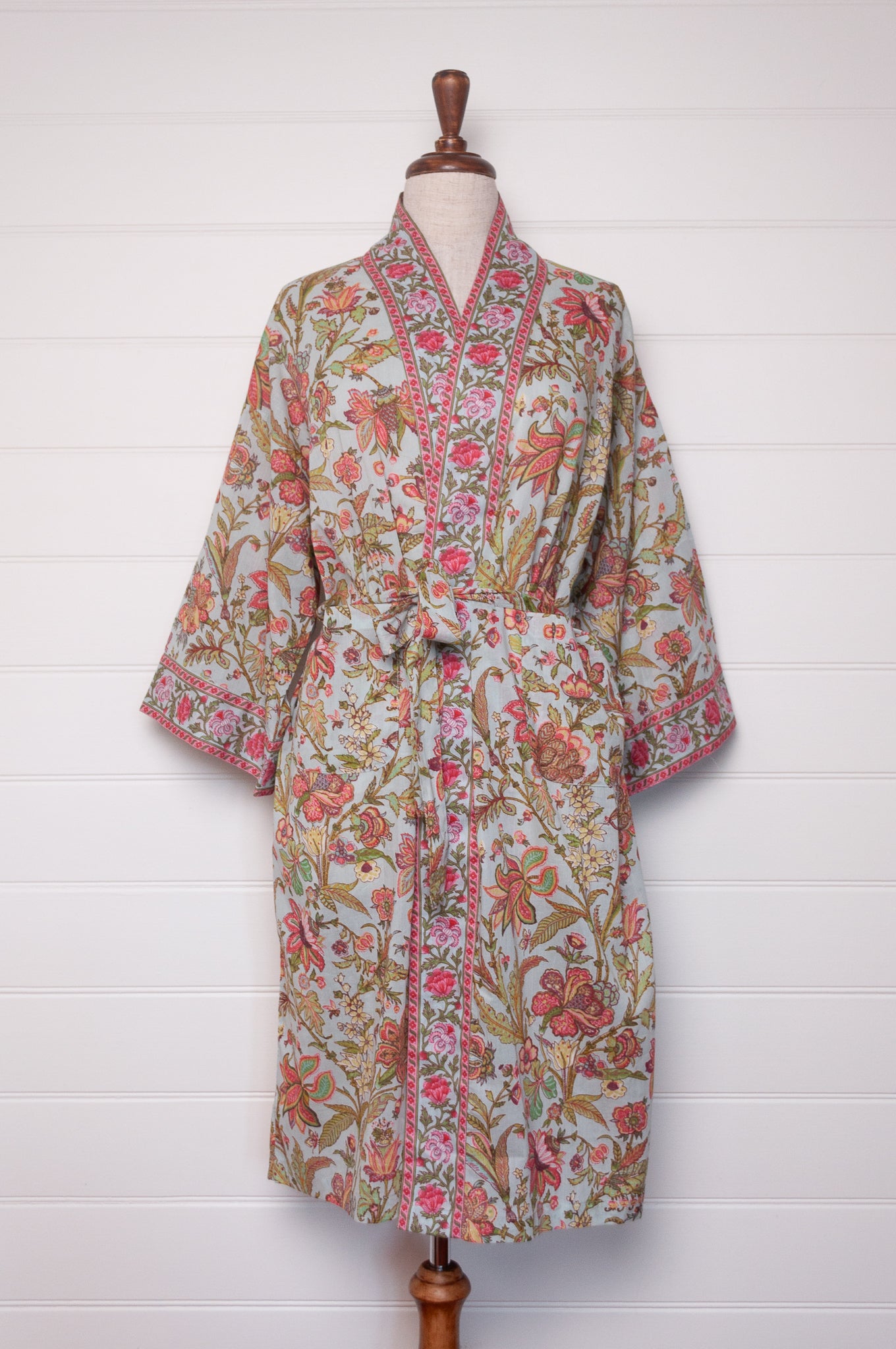 Juniper Hearth cotton voile kimono in tropical sky print, pink and lime green flowers on celadon blue background.