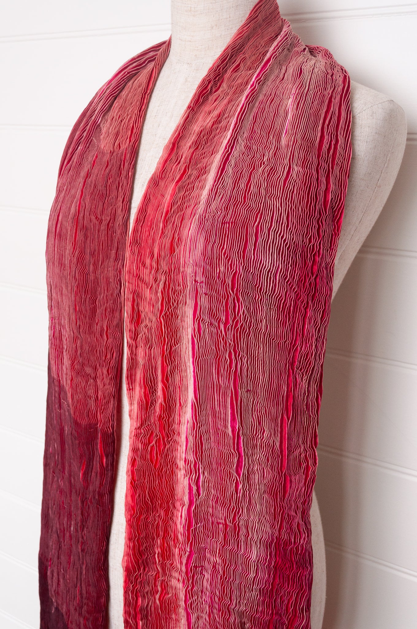 Crinkle shibori silk scarf in tones of magenta pink.