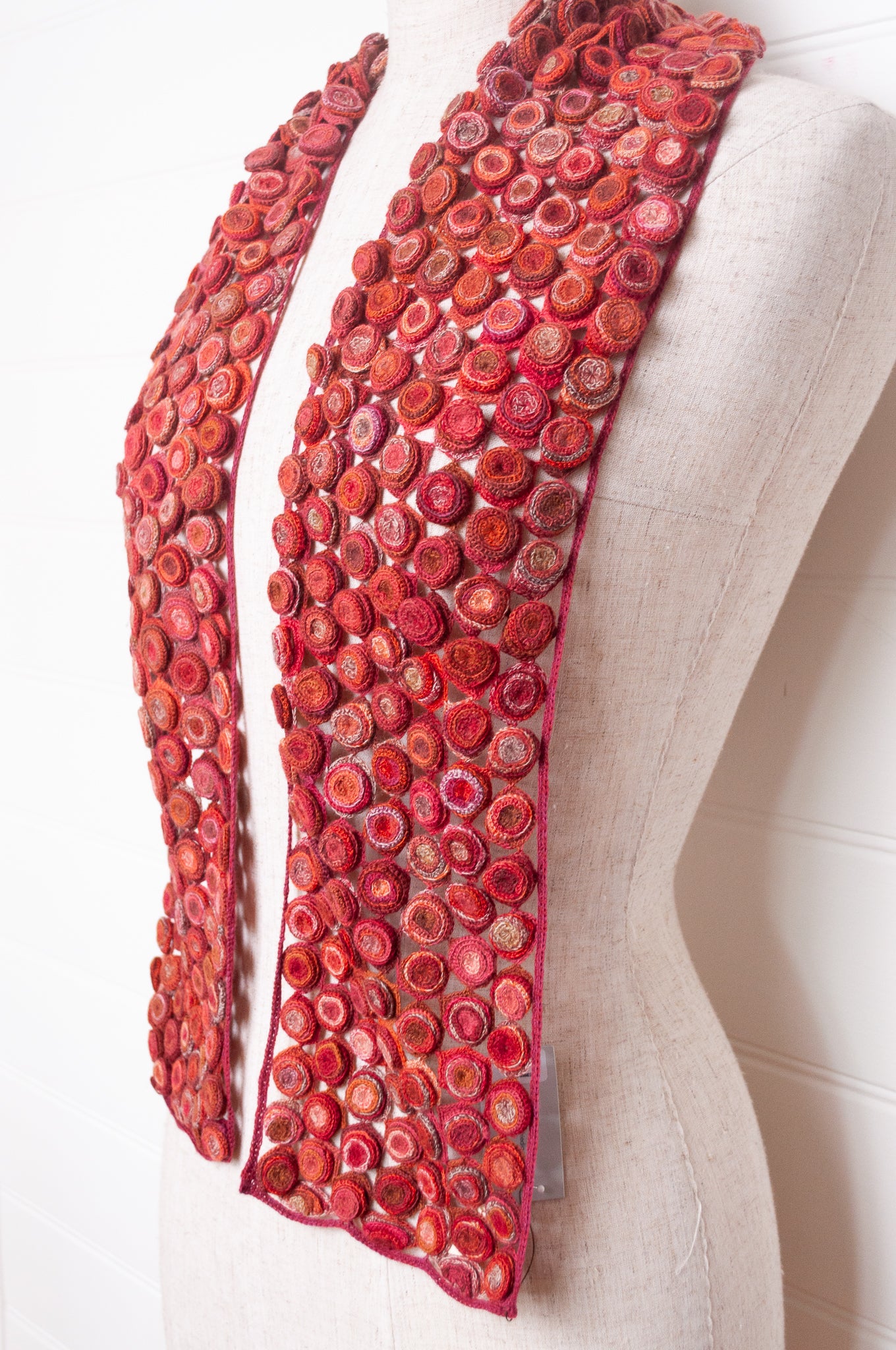 Sophie Digard crochet wool scarf with layered circle medallions in rich red, pink and rust palette.