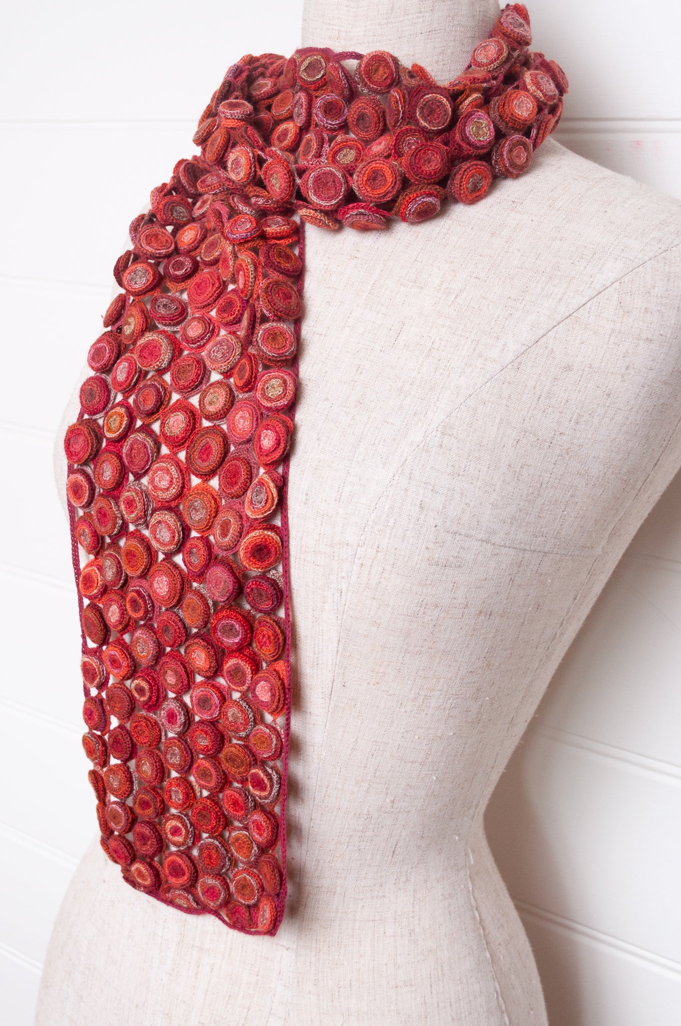Sophie Digard crochet wool scarf with layered circle medallions in rich red, pink and rust palette.