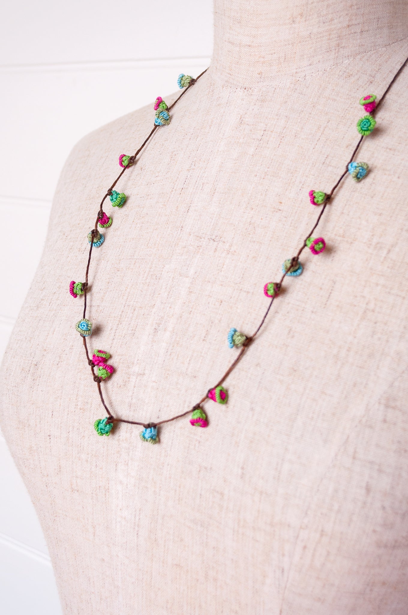 Handmade Moroccan button necklace in blue, pink and soft green.