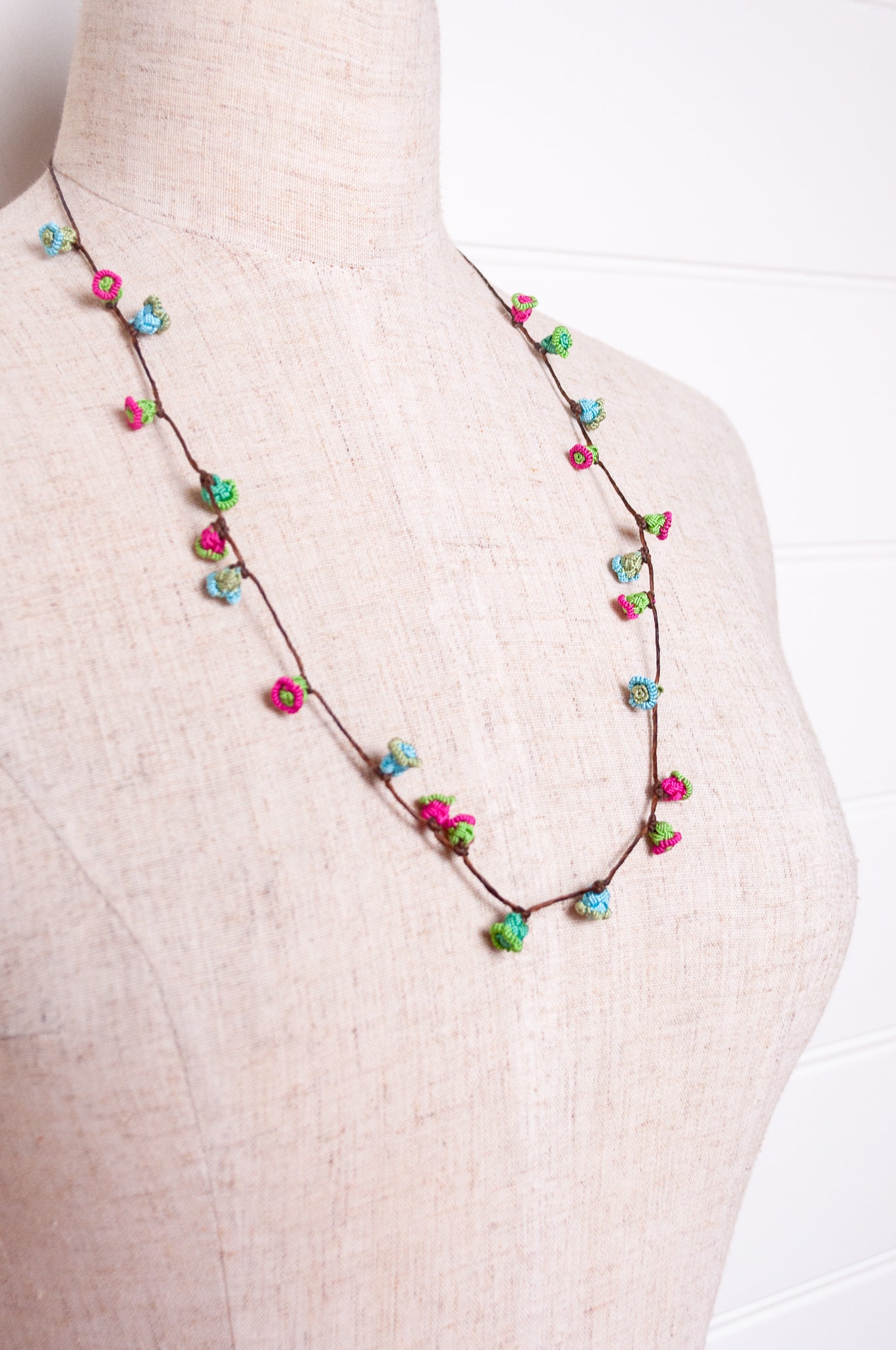 Handmade Moroccan button necklace in blue, pink and soft green.