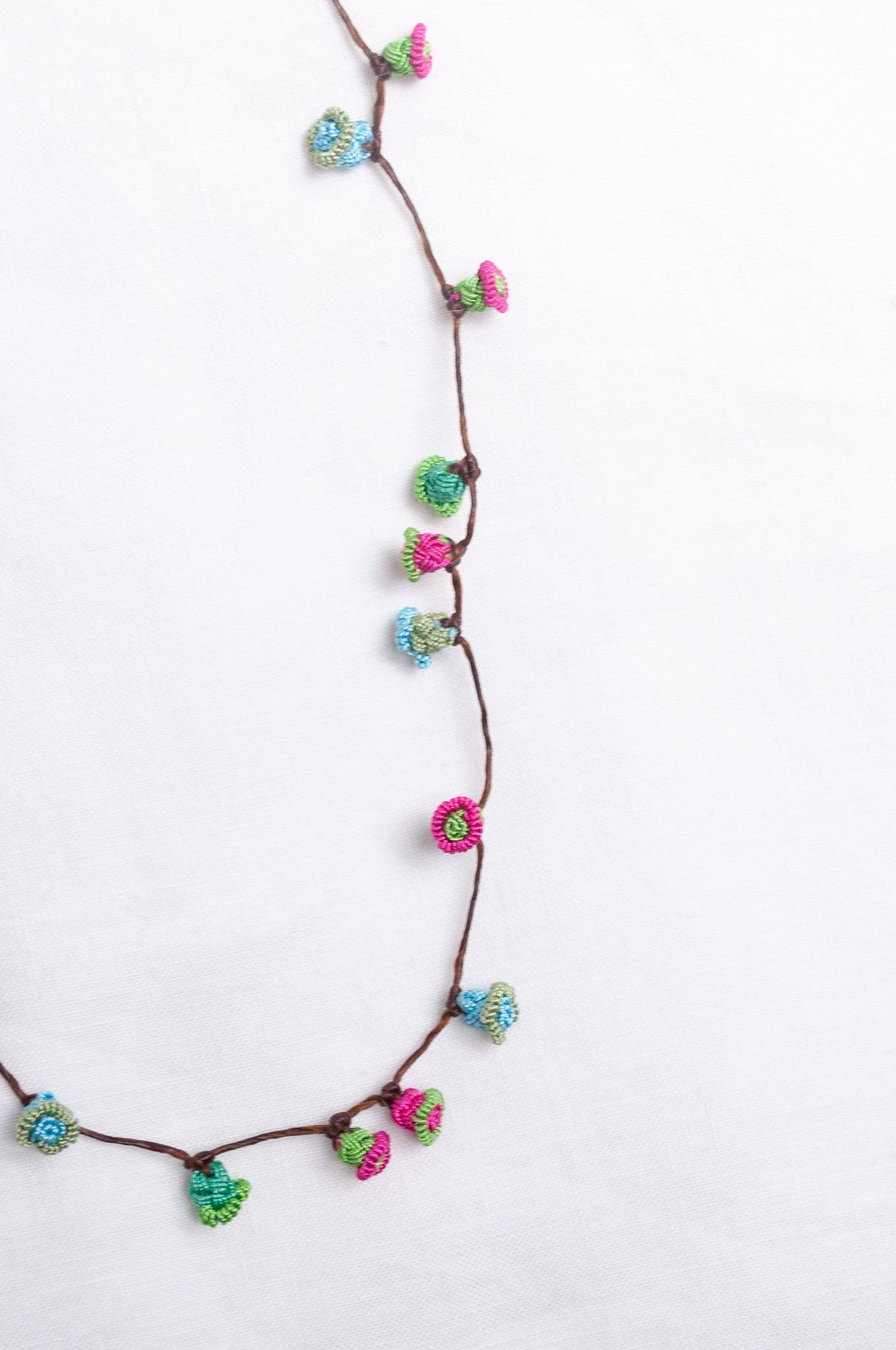 Handmade Moroccan button necklace in blue, pink and soft green.