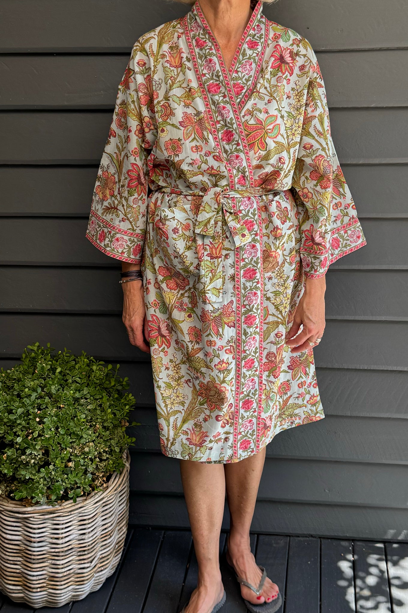 Juniper Hearth cotton voile kimono in tropical sky print, pink and lime green flowers on celadon blue background.