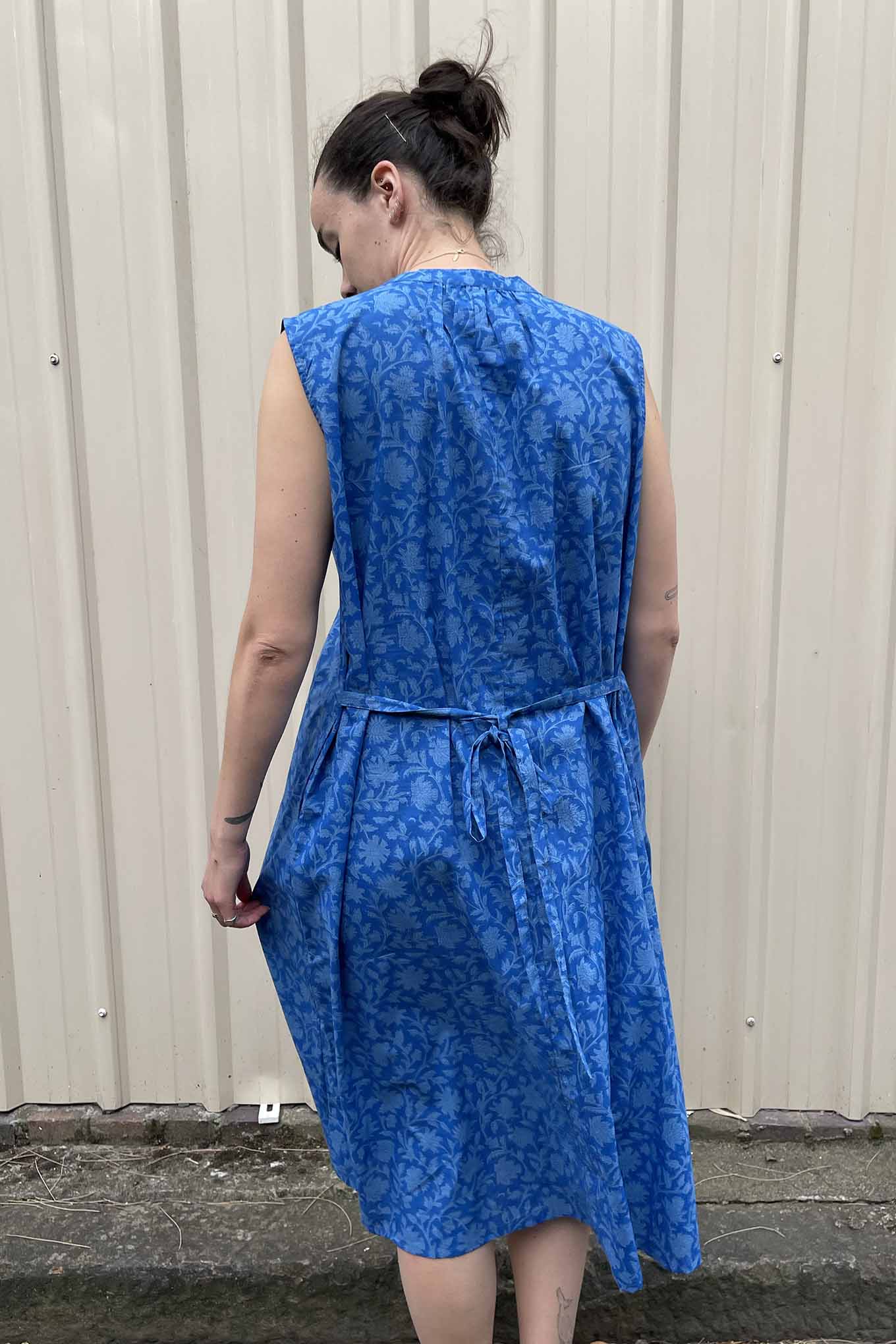 Juniper hearth Zoe dress button up sleeveless with waist ties, made from cotton cornflower blue blockprint floral.