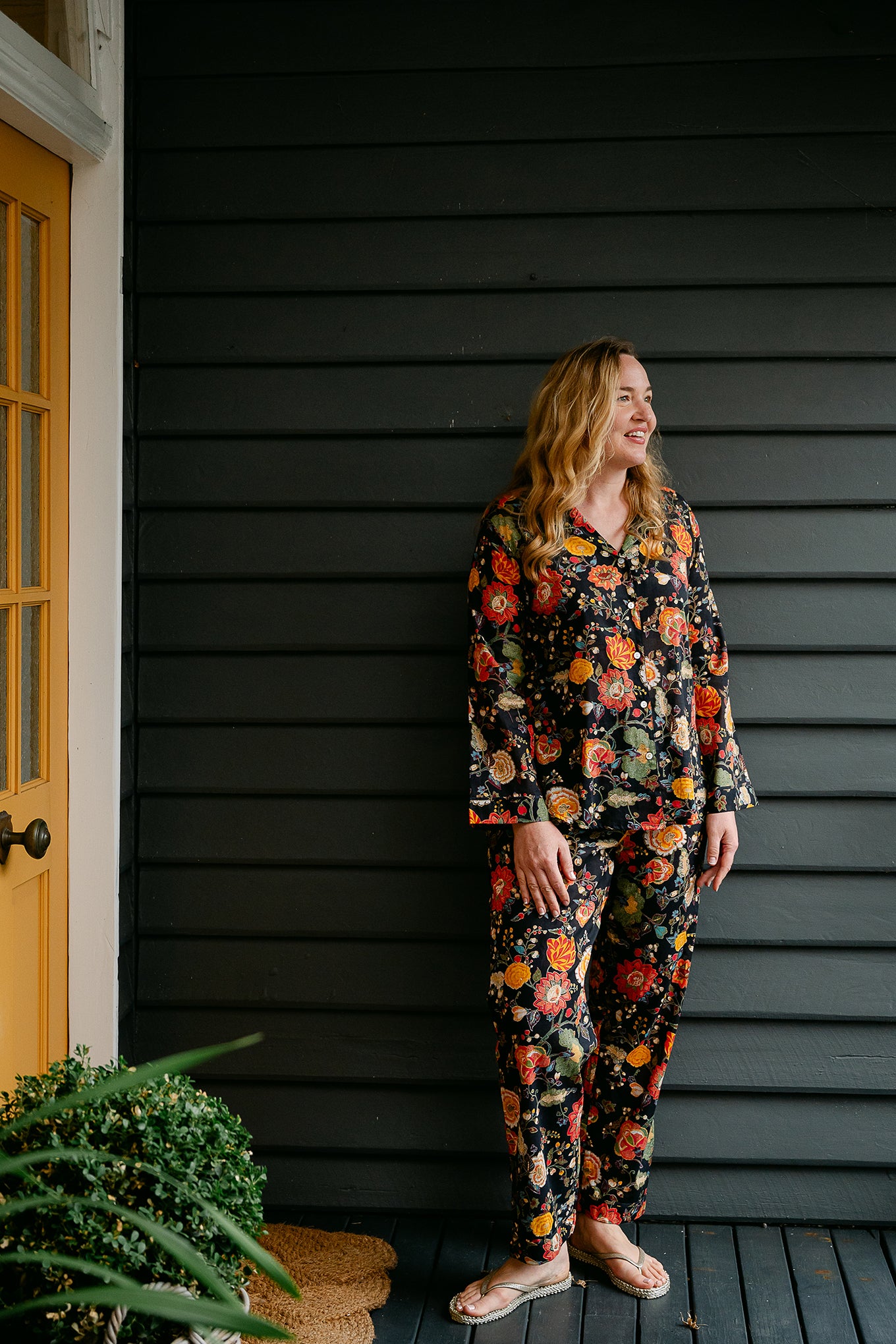 Ethically made cotton voile pyjamas, tropical print of red, gold and orange flowers on black background.