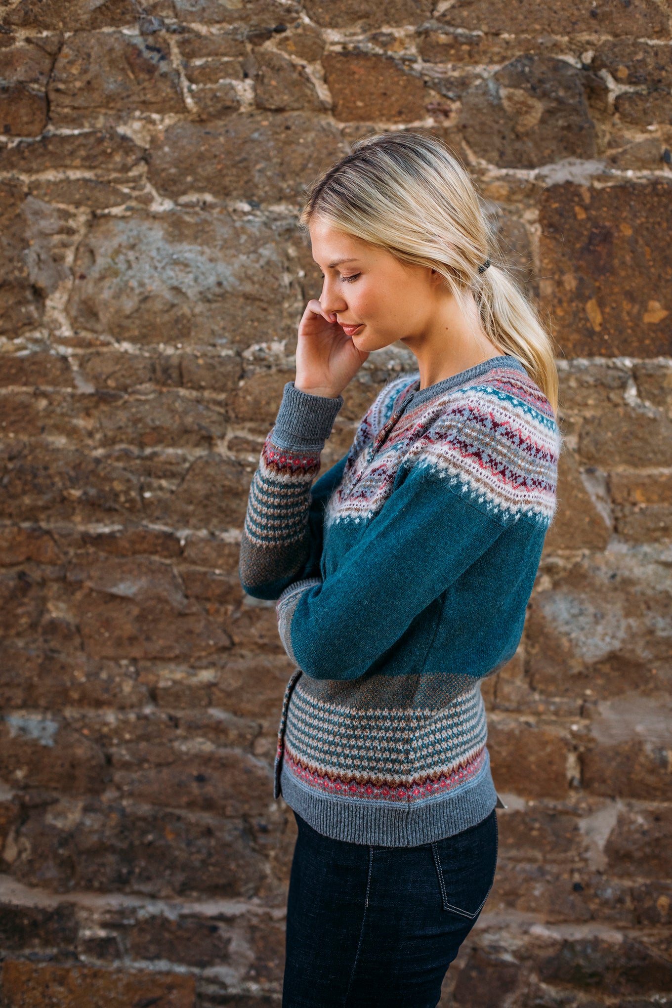 Eribé Alpine cardigan in Lugano, features a rich teal body, with highlights in rust, burgundy, bright pink, ecru and soft blue grey.
