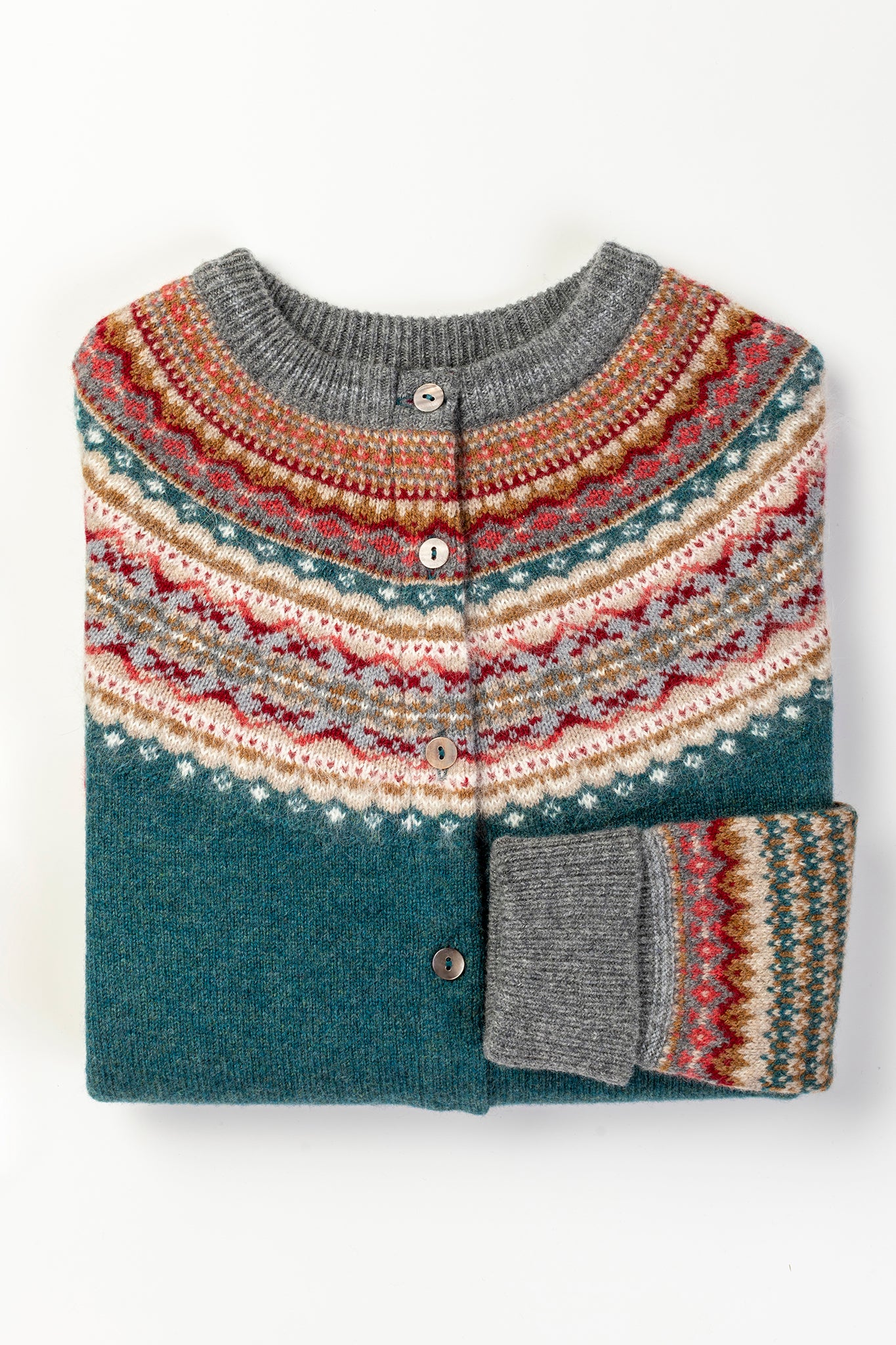 Eribé Alpine cardigan in Lugano, features a rich teal body, with highlights in rust, burgundy, bright pink, ecru and soft blue grey.