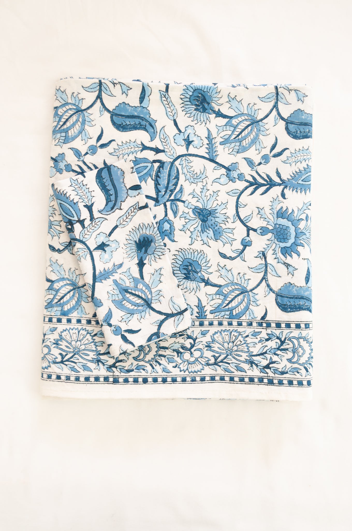 Ethically made artisan block print pure cotton table cloth, shades of blue on white floral design with border.