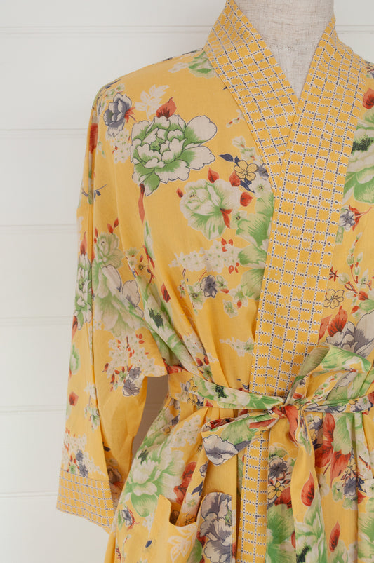 100% fine cotton voile kimono gown, screen printed by hand, peony floral print in shades of green, white, orange and grey on a butter yellow background, contrast trim. Ethically made.