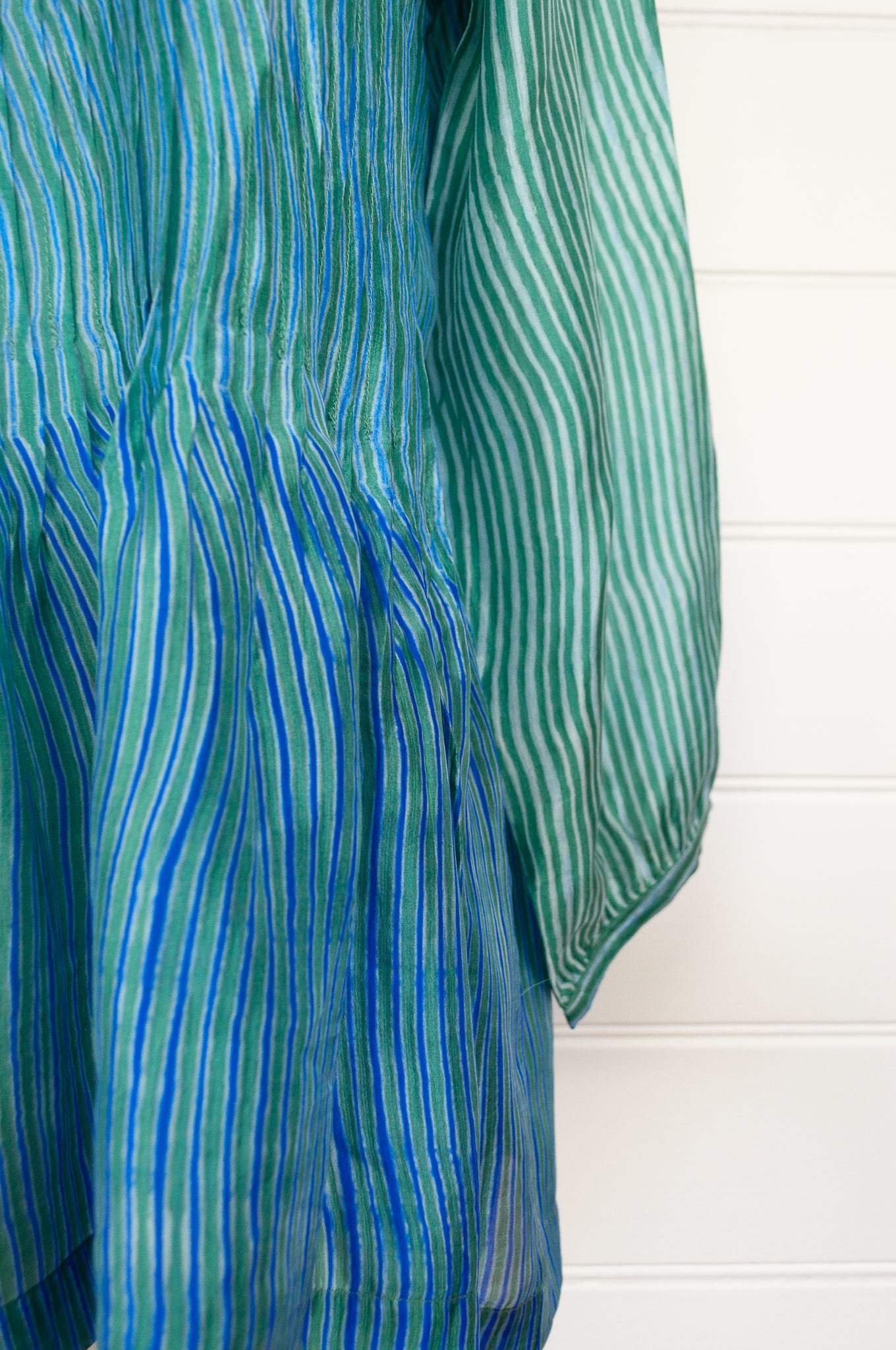 Juniper Hearth silk shibori Asha top with pin tucked bodice and long sleeves in aqua with vibrant blue accents.