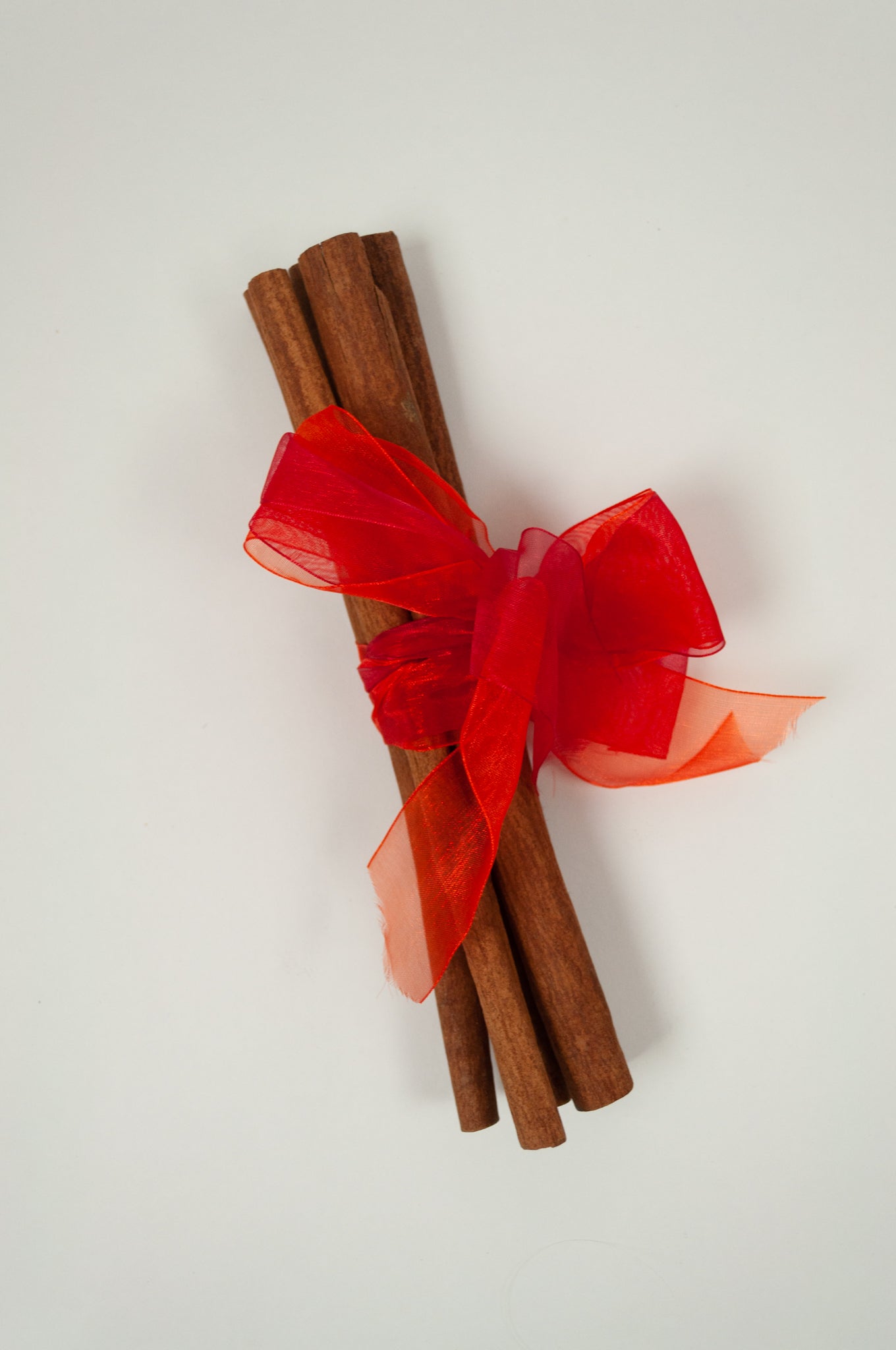 Juniper Hearth cinnamon stick bundles tied with brightly coloured organza ribbons.
